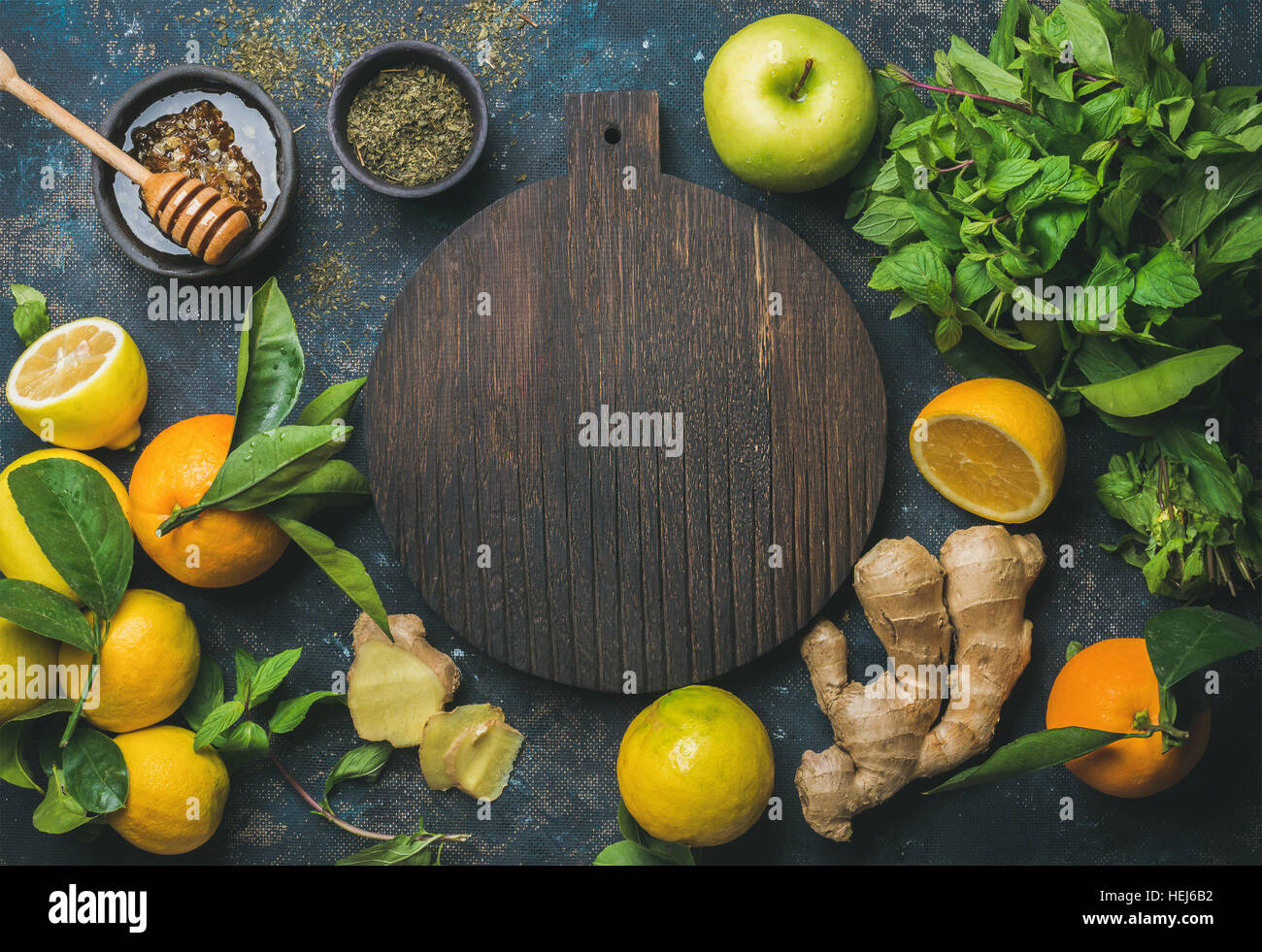 Les oranges, citrons, gingembre, menthe, miel, pomme, planche de bois dans le centre Banque D'Images