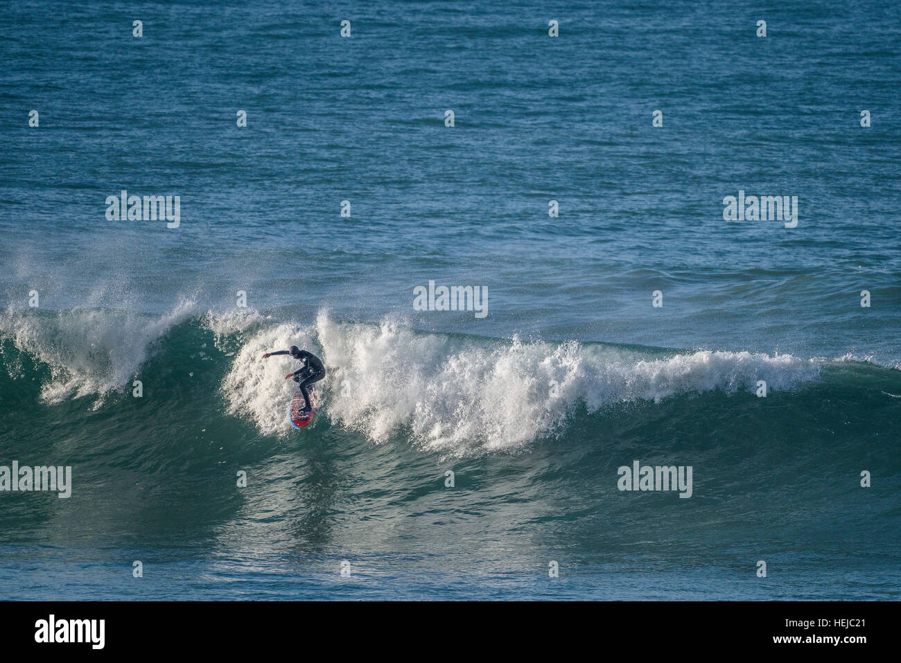 Un surfer rides une grosse vague à peu dans Fistral Newquay, Cornwall Banque D'Images