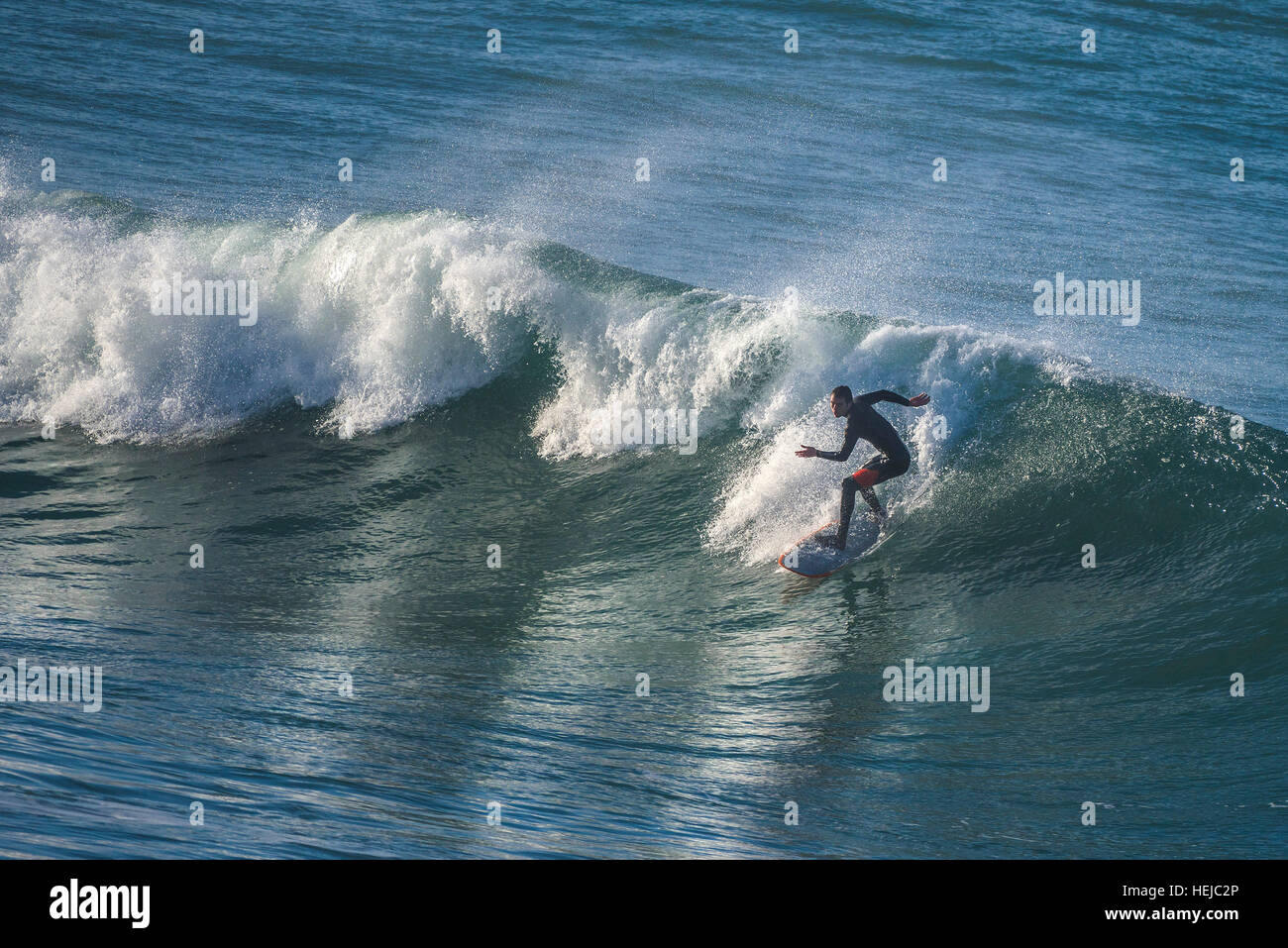 Un surfer rides une grosse vague à peu dans Fistral Newquay, Cornwall Banque D'Images
