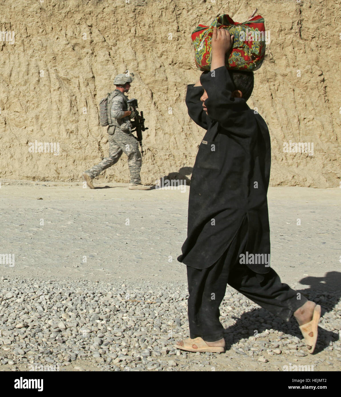 Un soldat de l'armée américaine, à partir de contingents d'Apache, 1er Escadron, 40e Régiment de cavalerie, passe un garçon afghan alors qu'il effectuait une patrouille à pied avec son peloton près de l'avant poste Herrera, province de Paktiya, Afghanistan, le 11 octobre 2009. Les soldats étaient à la recherche de sites à partir de laquelle les Talibans a été l'aide à lancer des roquettes à l'avant-poste. Soldats en patrouille 213169 Banque D'Images