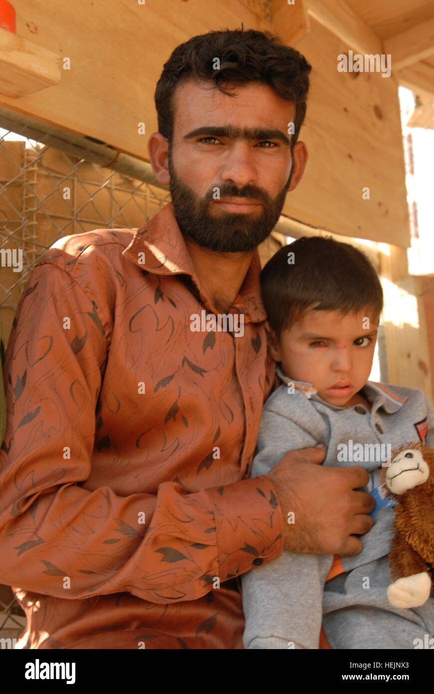 Saleh et son 4-année-vieux fils, Mahdi, attendre aux portes de la base d'opérations d'urgence à Bassorah le 18 novembre pour mot sur la question de savoir si les troupes américaines de les aider. Mahdi a été blessé lorsqu'un insurgé attaque au mortier a frappé sa maison. Après une évaluation, les soldats de Bassora S/N ont été en mesure d'organiser les consultations avec un neurochirurgien et un ophtalmologiste pour le garçon. (U.S. Photo de l'armée par la CPS. J. Princeville Lawrence) Sauvegarde Mahdi, soldats de l'exploitation d'urgence pour aider le travail de Basra Iraq boy 246432 blessés Banque D'Images