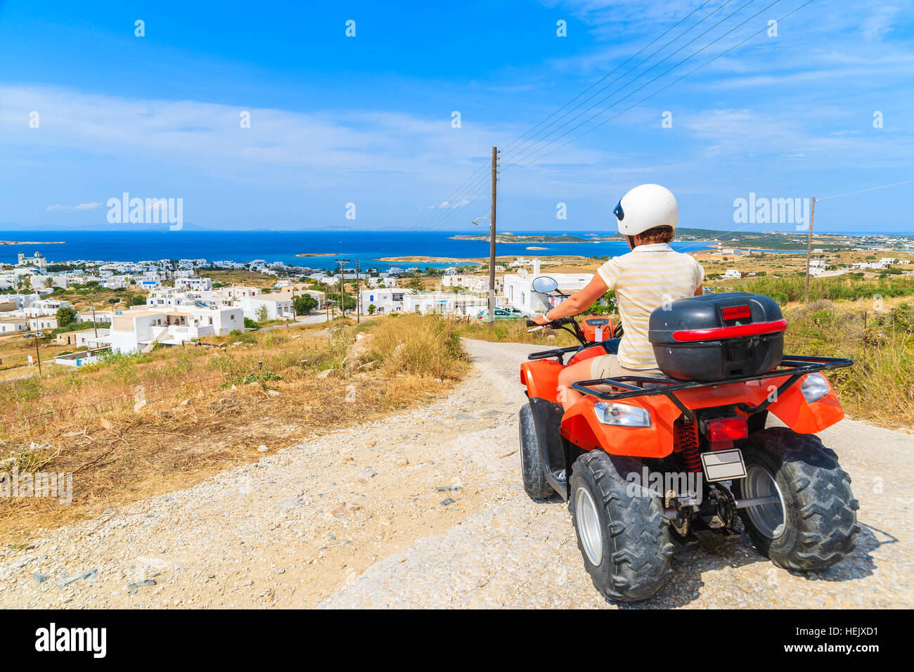 Jeune femme quad conduite sur route de gravier sur l'île de Paros, Grèce Banque D'Images