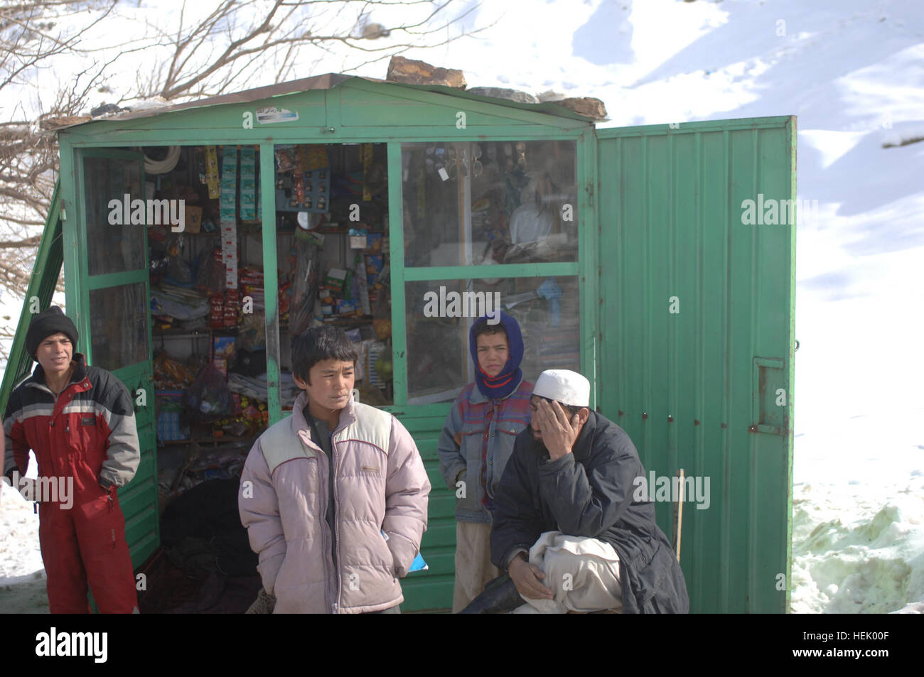 Un homme afghan et certains enfants s'asseoir devant leur magasin sur le chemin qui mène à l'tunnel de Salang. Les membres de la Compagnie de la Police militaire de la 410th de Fort Hood, au Texas, a livré des marchandises à l'aide humanitaire locale afghane dans le district de Salang ressortissants de l'Afghanistan, le 10 février. L'opération Enduring Freedom 250300 Banque D'Images