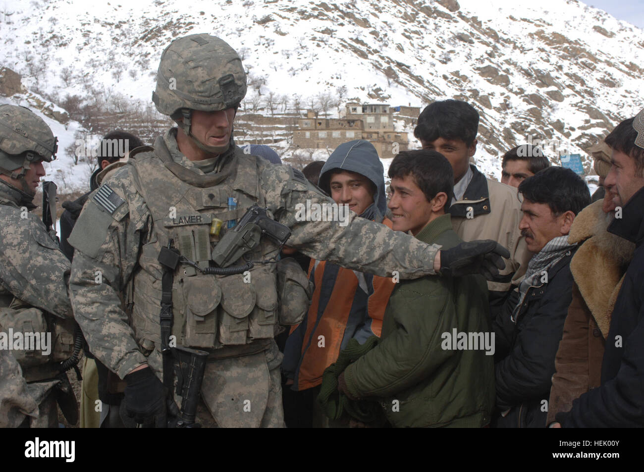 La CPS. Nathan un Lamer maintient l'ordre de la Police militaire en retenant un groupe d'Afghans alors que d'autres membres de la Compagnie de Police Militaire 410th passer dehors l'aide humanitaire. Les membres de la Compagnie de la Police militaire de la 410th de Fort Hood, au Texas, a livré des marchandises à l'aide humanitaire locale afghane dans le district de Salang ressortissants de l'Afghanistan, le 10 février. L'opération Enduring Freedom 250303 Banque D'Images