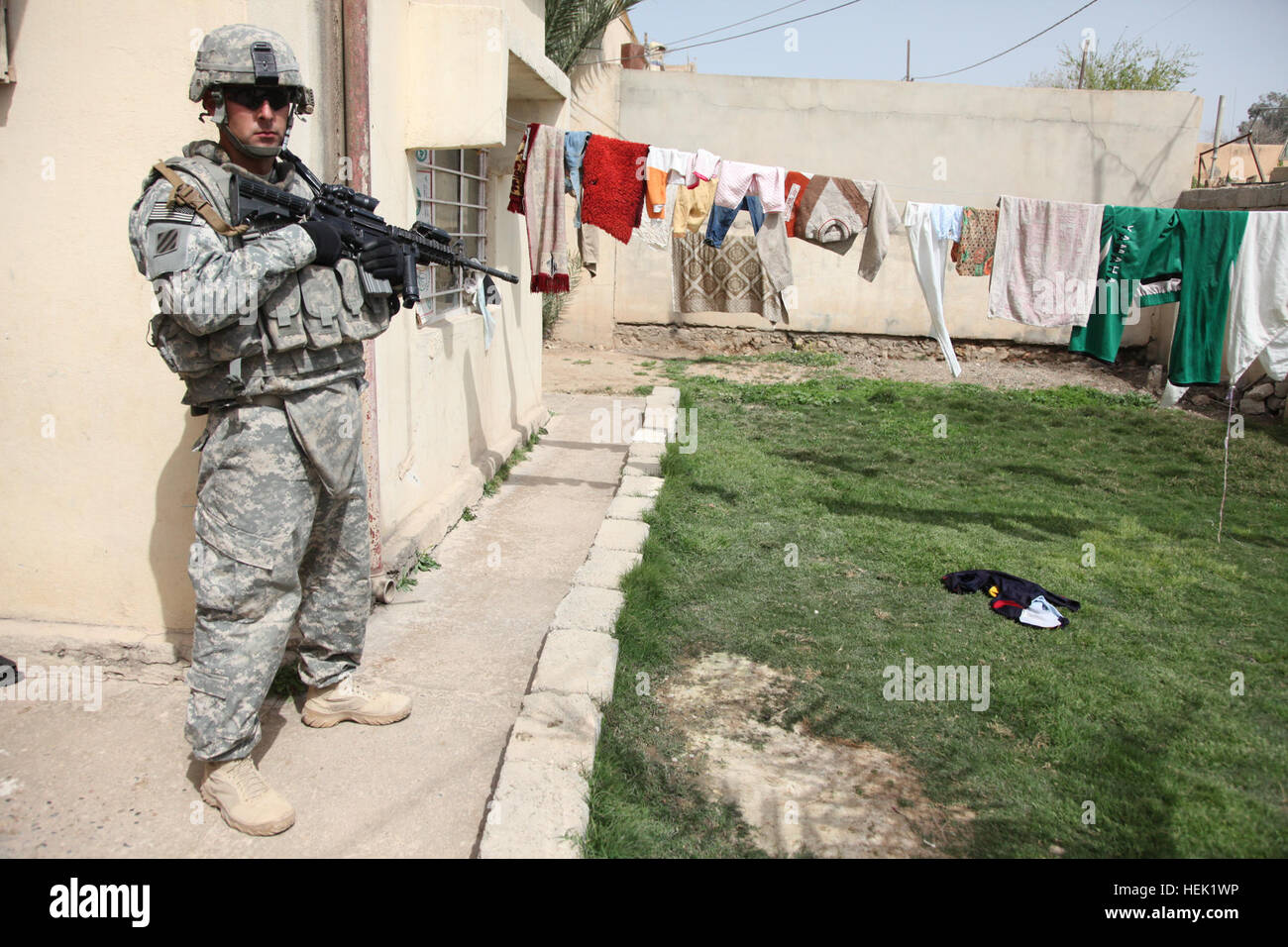 Le sergent de l'armée américaine. John Whipple, Crazy Horse Troop, 3e Escadron, 7e régiment de cavalerie, 2e Brigade Combat Team, 3e Division d'infanterie, tire sur la sécurité à l'extérieur d'une maison à Badoush, l'Iraq, le 3 avril. Whipple et son équipe sont la collecte d'informations sur la population locale. Évaluation ville 269780 Banque D'Images