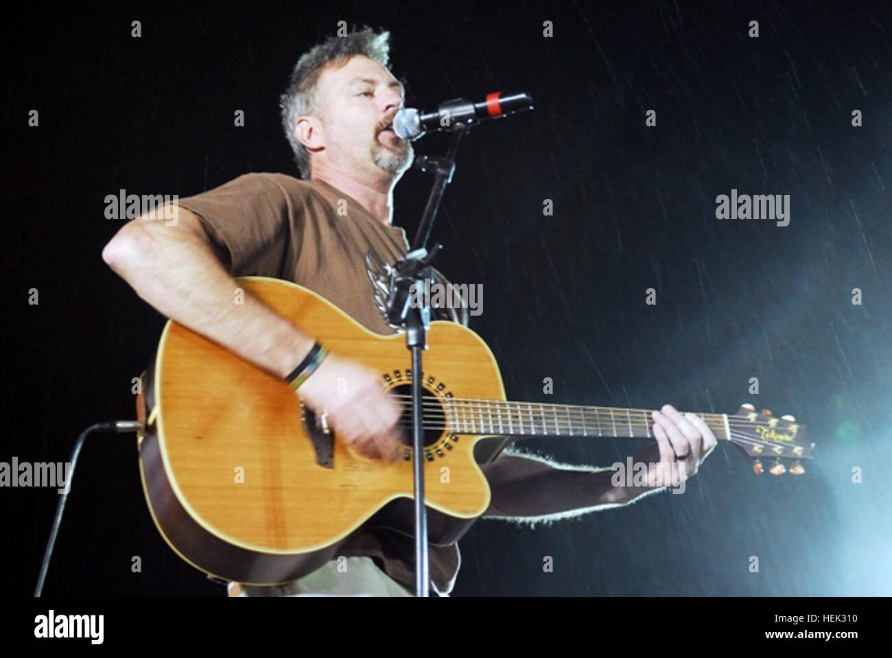 La chanteuse de country et compositeur, Darryl Worley, effectue au cours d'un concert gratuit, malgré la pluie, pour la base d'opérations d'urgence sur servicemembers Speicher, le 30 avril. La pluie n'a pas refroidir l'enthousiasme de l'auditoire que le groupe a joué dans des conditions défavorables. La chanteuse de country américaine appuie les soldats Concert gratuit 278799 Banque D'Images