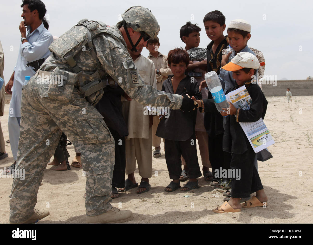 Un soldat de l'armée américaine, serre la main avec un petit garçon afghan au cours de groupe de travail gris fer visite dans un camp de réfugiés à l'extérieur de ville Mether Lam. L'objectif de la visite est de distribuer les radios locales 1000 parmi les réfugiés à tenter de les rapprocher du gouvernement afghan, le 2 juin. Nous, soldats afghans visiter Mehtar Lam 288056 Banque D'Images