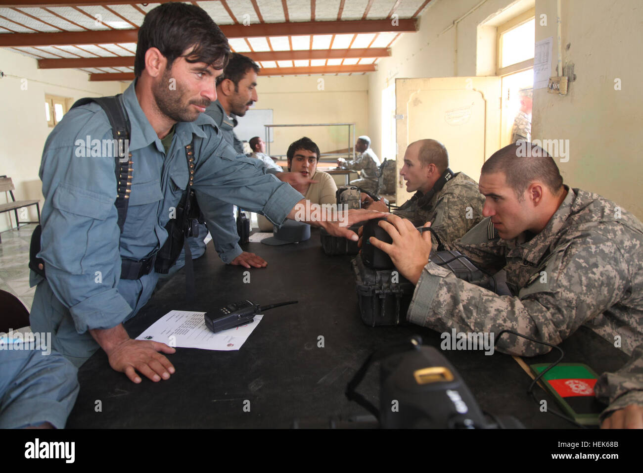 Équipe spéciale Currahee soldats du peloton de police militaire, des troupes spéciales 4e brigade bataillon, 4e Brigade Combat Team, la 101e Division aéroportée, recueillir des renseignements personnels à partir de la police en uniforme afghane en utilisant Inner-Agency Poche l'équipement de détection d'identité lors de l'opération à la base d'opérations avancée Polaroid Rushmore, province de Paktika, Afghanistan, le 26 septembre. Polaroid 326141 Opération Banque D'Images