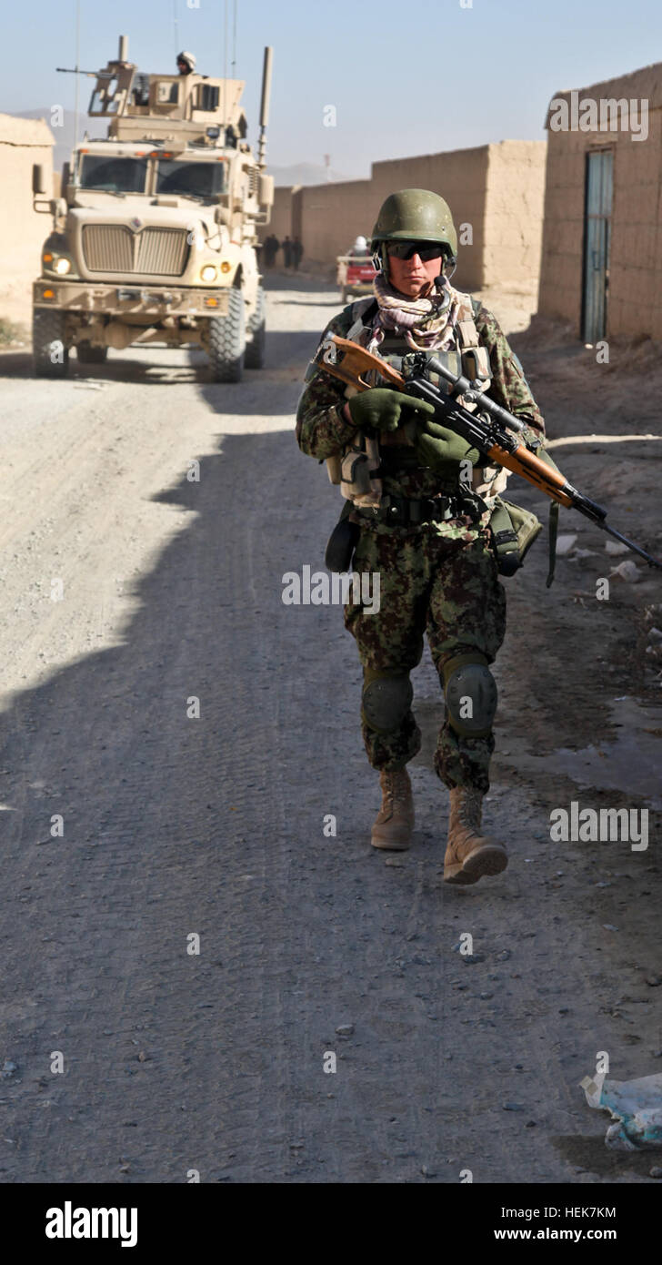 Un soldat nationale afghane le progrès tout en patrouille un soldat polonais tire sur la sécurité dans la ville de Ghazni, en Afghanistan. Les troupes afghanes, et de policiers en uniforme sont l'intensification de leur participation et de prendre un rôle plus actif dans la sécurité et la stabilité de l'Afghanistan, l'opération Enduring Freedom, le 20 novembre. (U.S. Photo de l'armée par le Sgt. Justin Howe) Patrol à Ghazni 343074 Banque D'Images