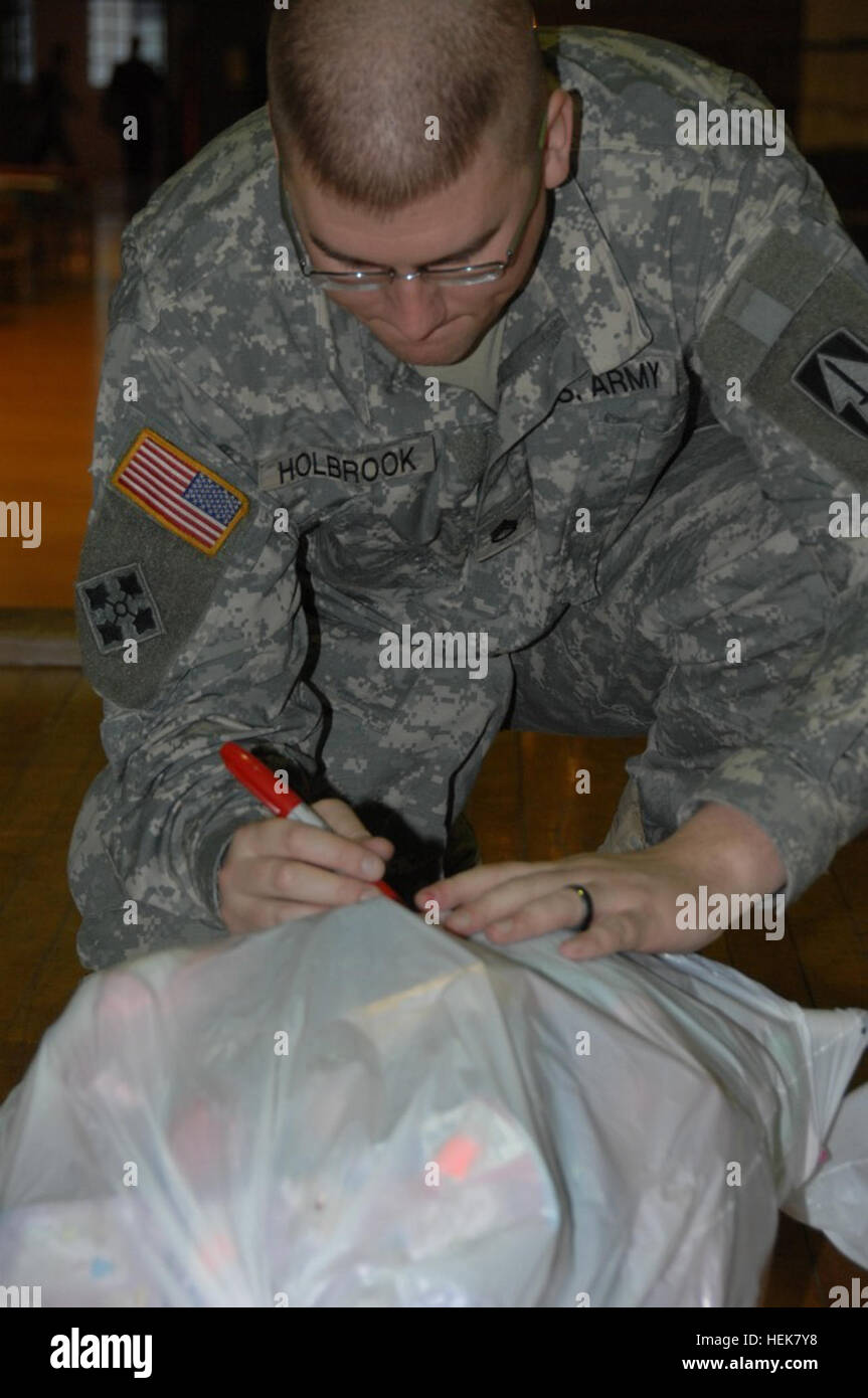 La Garde nationale de l'Indiana Le s.. Jason M. Holbrook, Columbus, Ind., preps un sac de jouets pour un autre enfant de soldat au cours de week-end de formation, samedi 4 décembre. Ces dons ont été transmis à la compagnie d'état-major d'infanterie, 76e Brigade Combat Team party de Noël, dimanche 5 décembre, à l'Armory Tyndall, à Indianapolis. La Garde nationale de l'Indiana (photo de la CPS. Katherine Forbes) Santa visite les militaires, les membres de la famille pour l'opération Homefront 349231 Banque D'Images