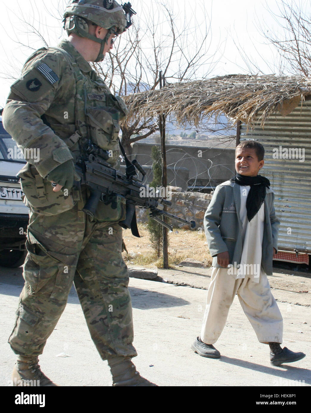 La CPS de l'armée américaine. Jonathan Huston, un artilleur de l'équipage d'infanterie avec la société C, 1er Bataillon, 133e Régiment d'infanterie, Task Force, Ironman de Iowa Falls, Iowa, parle avec un garçon afghan lors d'une patrouille à pied à travers le village de Alingar, Afghanistan, le 20 janvier. En plus de la patrouille, les soldats ont également assuré la sécurité d'une réunion entre les militaires et les agents des administrations locales, ainsi qu'une perquisition dans un village voisin pour des dispositifs explosifs de circonstance. Ironman TF est une partie de la 2e Brigade Combat Team, 34e Division d'infanterie, TF Red Bulls, et la garde nationale de l'Iowa. Discuter des soldats de l'Iowa Banque D'Images