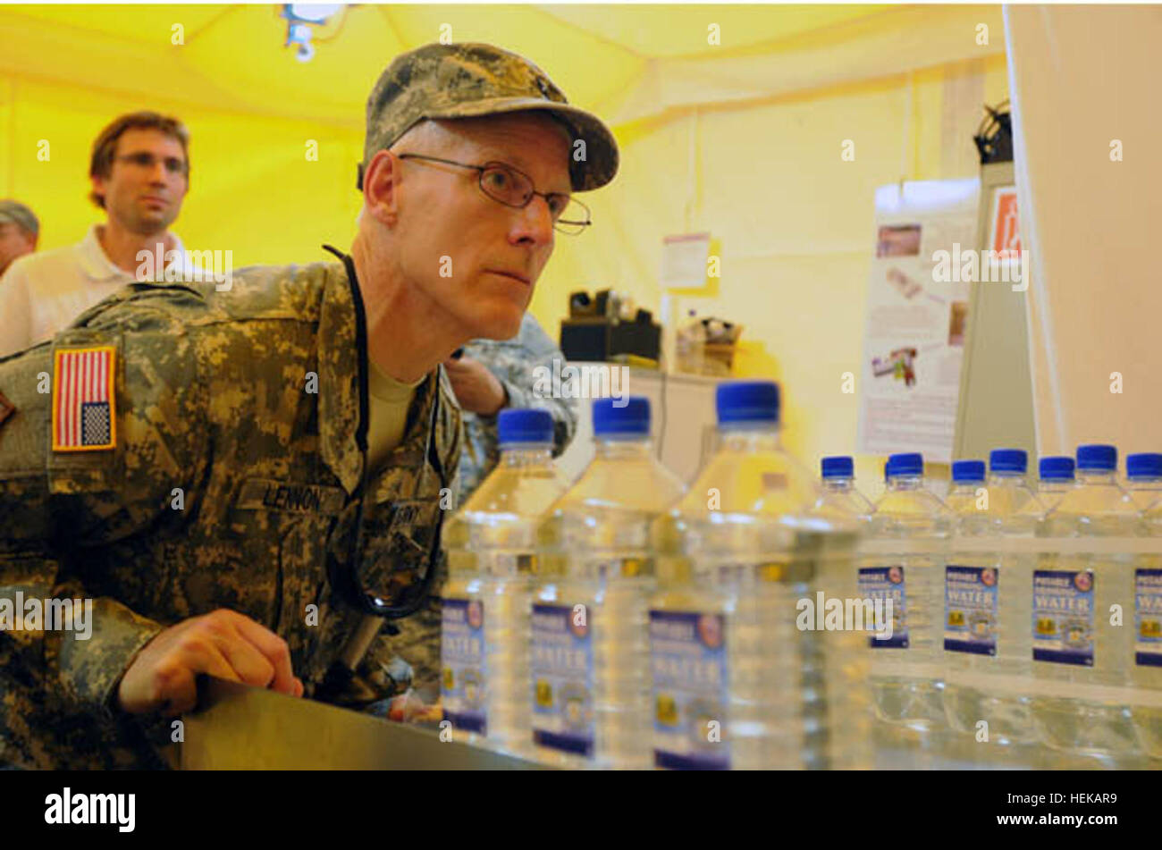 Le brig. Le général Peter S. Lennon, général commandant de la 316e Commandement de soutien expéditionnaire, observe le processus d'embouteillage de l'expéditionnaire Eau Emballage système via le hublot du système au cours de l'exercice logistique liquide Quartier-maître menée de juin 2011 à 17. De nombreuses unités sont associés au Fort Pickett, Va., de traiter, de purifier et de bouteille de l'eau d'un étang local en utilisant ce système et d'autres systèmes de purification de l'eau. Les soldats du quartier-maître de l'eau de l'étang de transformation dans l'eau potable à QLLEX 2011 414626 Banque D'Images