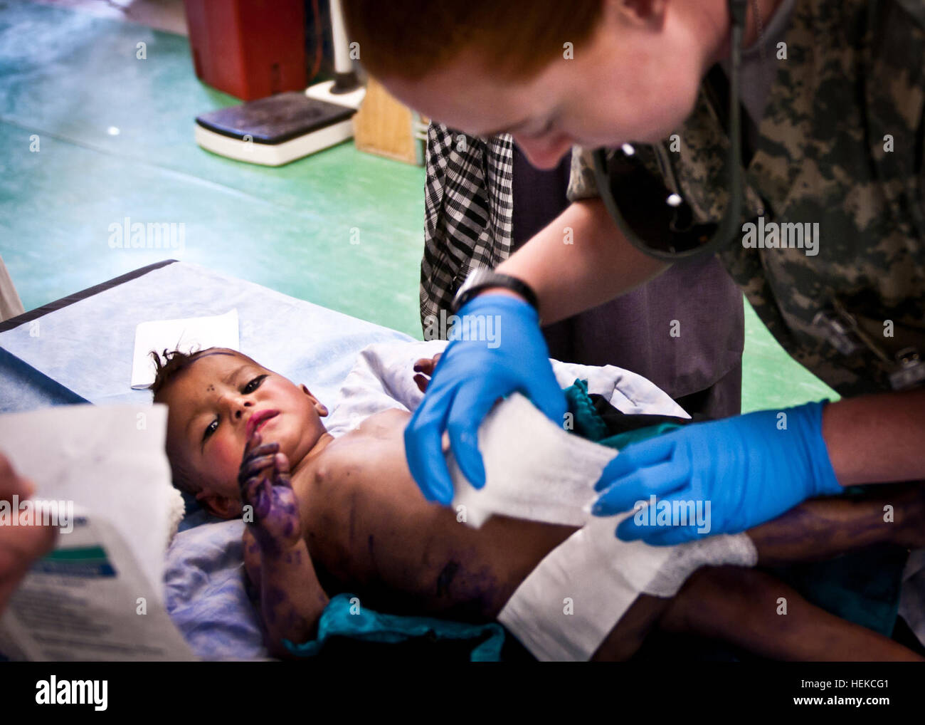 Air Force 1er lieutenant Sarah Thornton de Steubenville, Ohio, actuellement en service au 2e avant l'équipe chirurgicale de base d'Orgun-e s'applique, bandages et crème brûler à un enfant afghan a été brûlé plus de près de 50  % de son corps. Les parents n'ont pas été en mesure de recevoir un traitement de la clinique locale. Les forces de la coalition travaillent actuellement avec la communauté médicale locale pour rénover les cliniques et fournir des soins critiques à leurs citoyens. L'application de bandages 447108 Banque D'Images