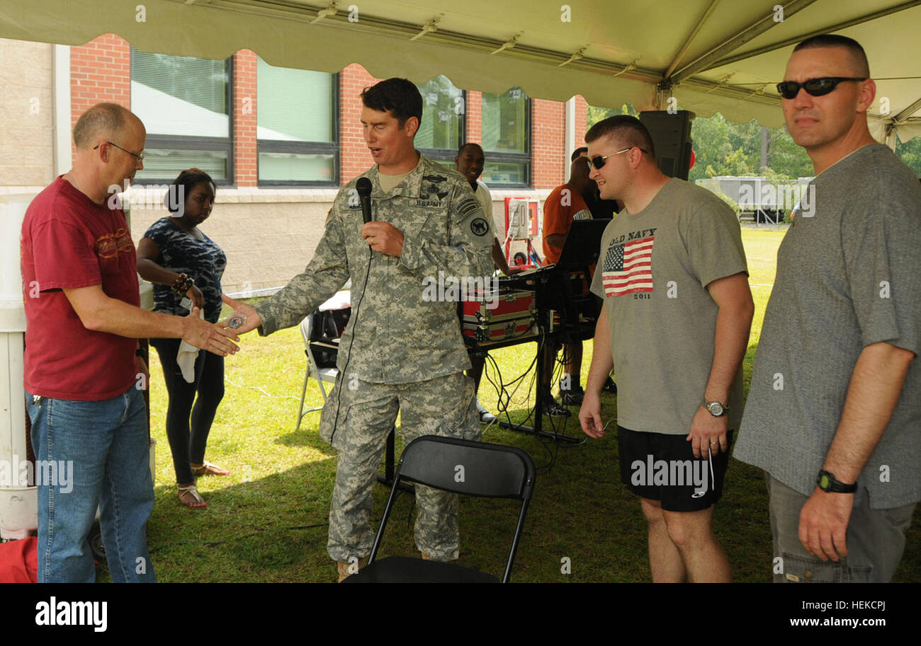 Le brig. Le Général Mark C. Arnold, commandant par intérim de la 81e Commandement du soutien régional, présente une pièce du commandant pour le s.. Jeremy Glasco pour ses efforts dans la cuisine 150 lb de porc à l'unité de la fête de la famille activités à Fort Jackson, L.C. (le 21 août 2011. Le s.. Glasco et les deux autres soldats restés sur place toute la nuit, assister à la lente-porc rôti que quelqu'un a nommé Carlos. L'Armée américaine photo par le Sgt. Joel 1ère classe 81e Commandement du soutien régional du Québec Bureau des affaires publiques du Commandement du soutien régional 81e jour de la famille 110821-A-IL912-082 Banque D'Images