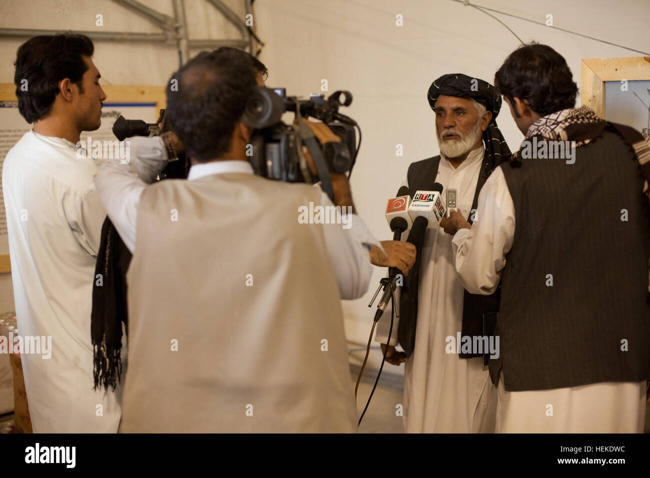 Les membres de l'Afghanistan médias interview Niaz Mohammad Sarhadi, gouverneur de district, district de Zharay, après une réinsertion shura à l'avant de la base de l'opération, Zharay Pasab district, l'Afghanistan, le 19 septembre, 2011. La shura est de coordonner le processus de réintégration dans l'ensemble de l'Équipe spéciale Spartan Secteur d'opérations et de célébrer la libération des prisonniers dans le cadre du processus de réintégration. Shura réinsertion tenue le fonctionnement marche avant 110919 Base Pasab-A-QD683-437 Banque D'Images