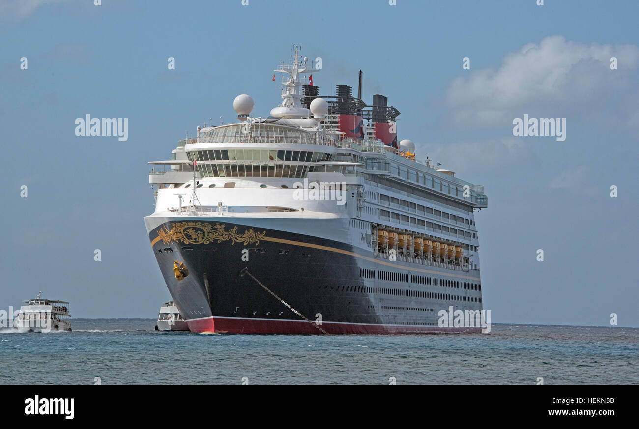 Transport des passagers vers l'île. 18Th Oct, 2016. Le Disney Wonder est une croisière navire exploité par Disney Cruise Line, qui transporte 2 400 passagers et 945 membres d'équipage, dans le port de George Town, Grand Cayman, îles Caïmans le mardi 20 décembre 2016. Les plus petites embarcations sont les offres qu'au transport des passagers d'avant en arrière pour l'île. - Pas de service de fil - Photo : Ron Sachs/consolidé/dpa/Alamy Live News Banque D'Images