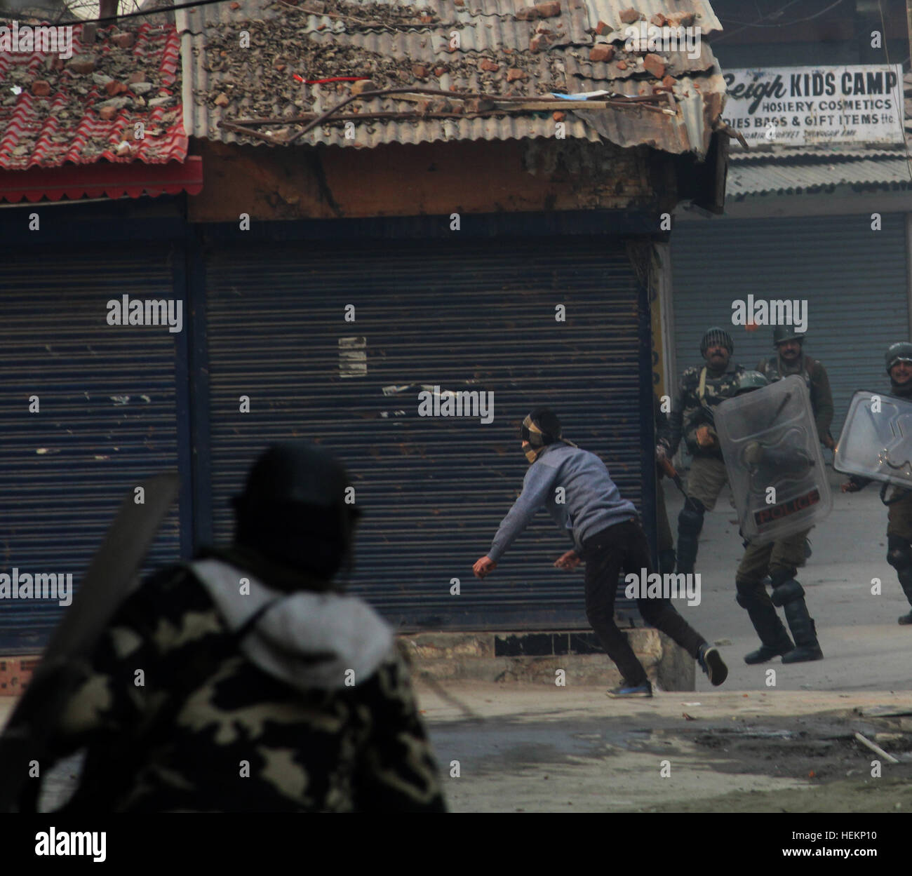 Srinagar, au Cachemire. 23 Décembre, 2016. Soldats paramilitaires indiennes chase un manifestant du Cachemire au cours d'une manifestation après la prière du vendredi à Srinagar, au Cachemire. Les séparatistes cachemiris ont protesté contre l'émission de certificats de domicile à 'l'ouest du Pakistan, les réfugiés hindous des réfugiés du Pakistan qui ont migré en 1947 à Jammu-et-Cachemire de l'Inde à partir de l'état de la province de Punjab au Pakistan pendant l'émeutes communales. Un certificat de domicile permet au titulaire de fournir une preuve de résidence : Crédit sakib makhdoomi/Alamy Live News Banque D'Images