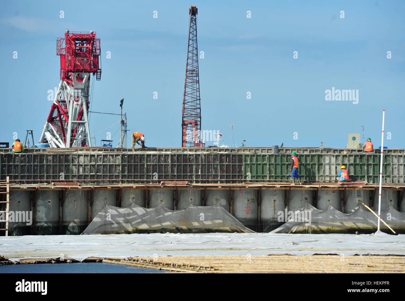Jakarta, Indonésie. 26Th Dec 2016. Travailleurs construisent un mur qui sera utilisé comme une barrière pour empêcher l'eau de mer de circuler sur terre et inondations à Muara Baru à Jakarta, Indonésie, le 23 décembre 2016. © Zulkarnain/Xinhua/Alamy Live News Banque D'Images