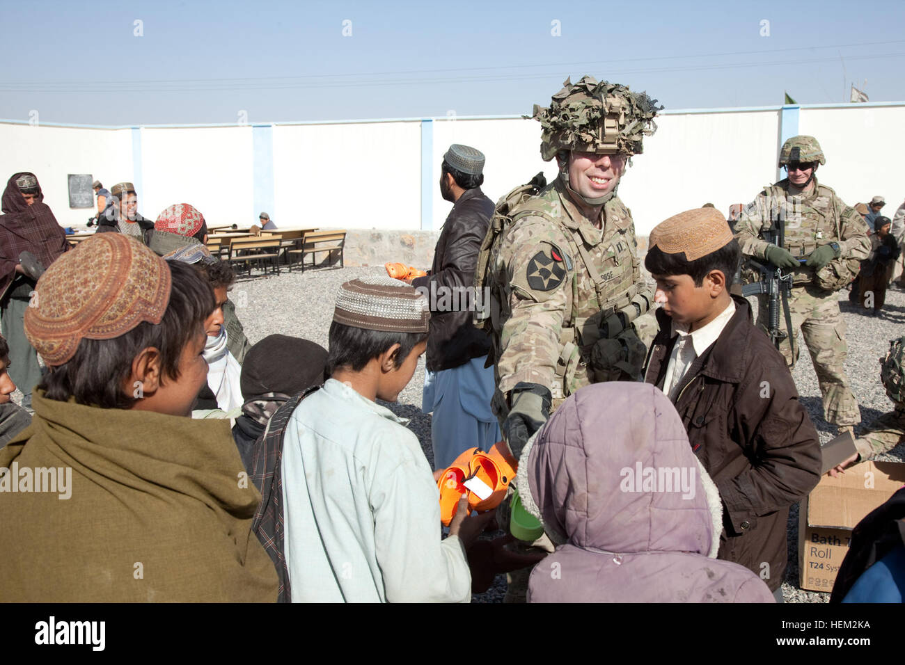 Le Capitaine Robert Rose, 5e Bataillon, 20e Régiment d'infanterie, 3e Brigade, 2e Division d'infanterie, les mains hors des chaussures pour les élèves de l'école, Zharay Pasab district, province de Kandahar, Afghanistan, le 14 février 2012. Des soldats de la Force opérationnelle combinée Spartan offrent des chaussures et des fournitures scolaires à l'école. L'opération Enduring Freedom 120214-A-QD683-050 Banque D'Images