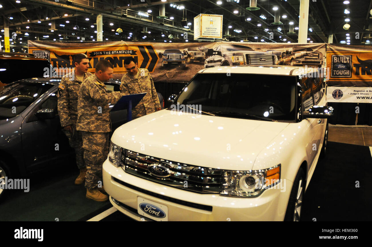 Affichage nouveau automobilesHouston - Spécialiste Daniel Leonard, SPC. Andrew Stilwell, les deux assistants médicaux de combat, et la FPC. Francisco Alarcon, un pétrolier, tous avec la société D, 1er Bataillon, 5e régiment de cavalerie, 2e Brigade Combat Team, 1re Division de cavalerie, Fort Hood, consulter les spécifications d'un Ford Flex 2012 à l'un des Ford Motor Co. pour exposition dans le Reliant Center pendant le Houston Livestock Show and Rodeo, 10 févr. 29. Tous les militaires en uniforme et leurs familles ont eu l'entrée gratuite dans le Reliant Park, rodéo et concert dans le cadre de la Journée de reconnaissance des Forces armées. (U.S. Photo de l'armée par le Sgt. Quenti Banque D'Images