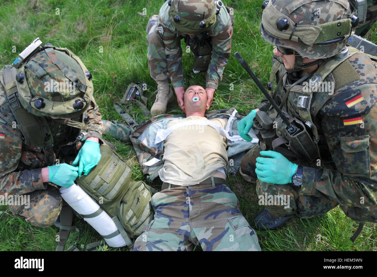 Deux soldats allemands de l'équipe de conseiller militaire et un soldat 3 Albanais de l'Armée nationale afghane, la réplication, fournir des soins médicaux à un soldat blessé au cours d'une équipe de liaison et de mentorat opérationnel (ELMO) de l'entraînement à la préparation interarmées multinationale Centre à Hohenfels, Allemagne, 10 mai 2012. XXIII de l'ELMO de la police et de l'Équipe de liaison et de mentorat opérationnel VII la formation sont conçus pour préparer les équipes de déploiement en Afghanistan avec la capacité de former, de conseiller et de permettre aux Forces nationales de sécurité de la Force dans des domaines tels que la contre-insurrection, combattre, consultatif et de travail permettant aux opérations de soutien. Banque D'Images