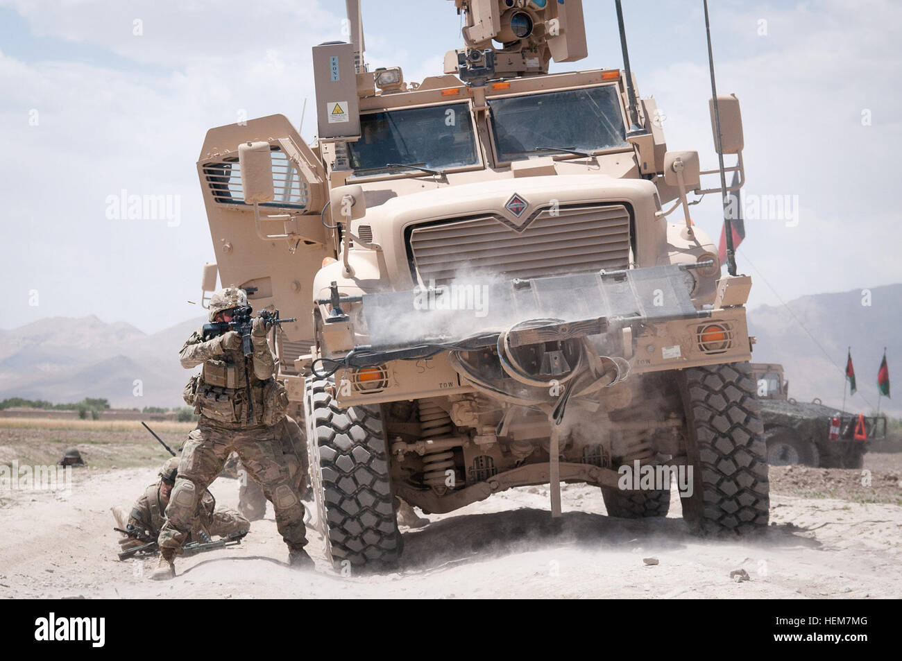 Un parachutiste de l'armée américaine avec la 82e Division aéroportée, 1ère Brigade Combat Team de forêt sa carabine M4 à insurgés durant un échange de tirs le 30 juin 2012, la province de Ghazni, Afghanistan. Le véhicule qu'il utilise pour couvrir est une mine et les embuscades véhicule protégé. (U.S. Photo de l'armée par le Sgt. Michael J. MacLeod, Task Force 1-82 OAP) 120630-A-3108M-036 Banque D'Images