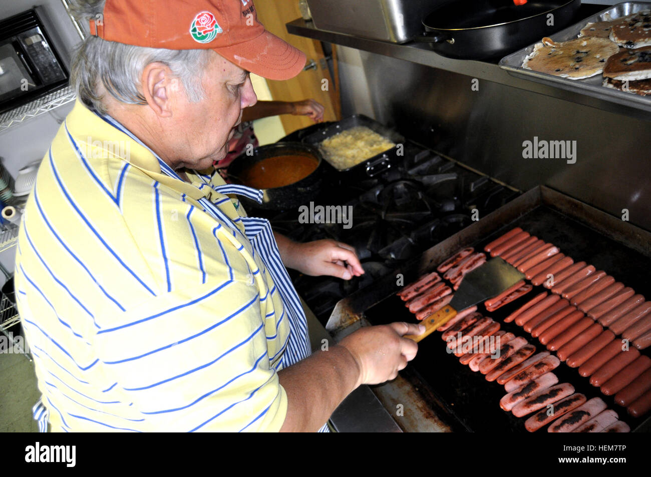 Robert Dorsett, un avocat à Austin, Texas, grils à hot dog dans le service de pompiers volontaires de Lewisburg cuisine le jeudi 5 juillet. Dorset et sa femme, Lori et fils, Travis, cuisinent pour la garde nationale de la Virginie de l'Ouest, de l'état et de la police locale et les pompiers pour la semaine dernière. Le Dorsetts s'est porté volontaire pour faire cuire et ont été l'achat de la majorité de la nourriture servie. Bon samaritain rss soldats, policiers et pompiers 620886 Banque D'Images