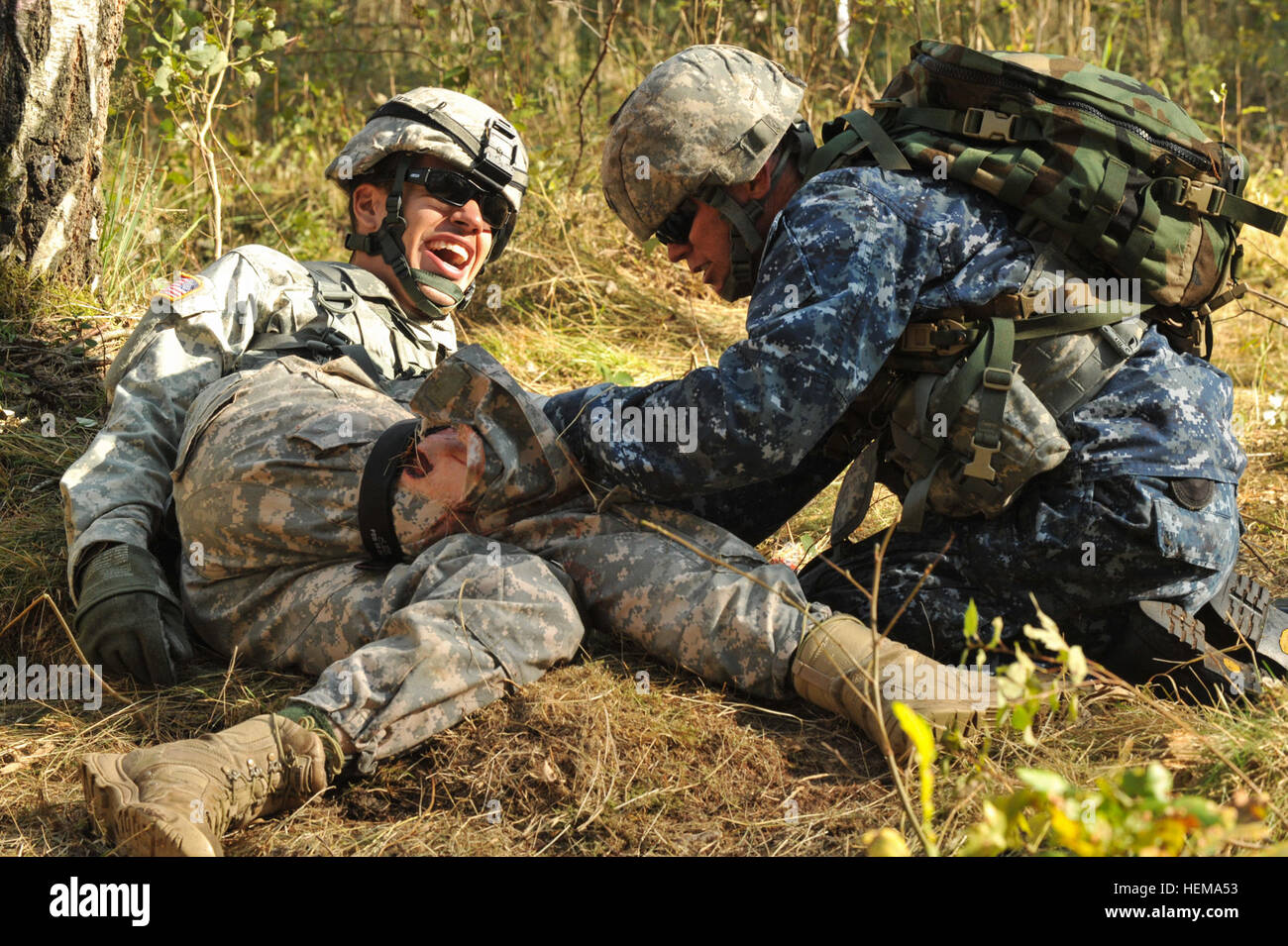 L'Hôpital de la marine américaine de deuxième classe Corpsman Sean Miller (à droite), attribué à l'Europe, commande médicale régionale applique un garrot sur une victime simulée au cours de la lutte contre l'Armée américaine à l'Europe de la concurrence sur le terrain par les experts en médecine d'un insigne Grafenwoehr, Allemagne, 18 septembre 2012. US Army Europe Expert médical de campagne 2012 Badge 120918-A-BS310-039 Banque D'Images