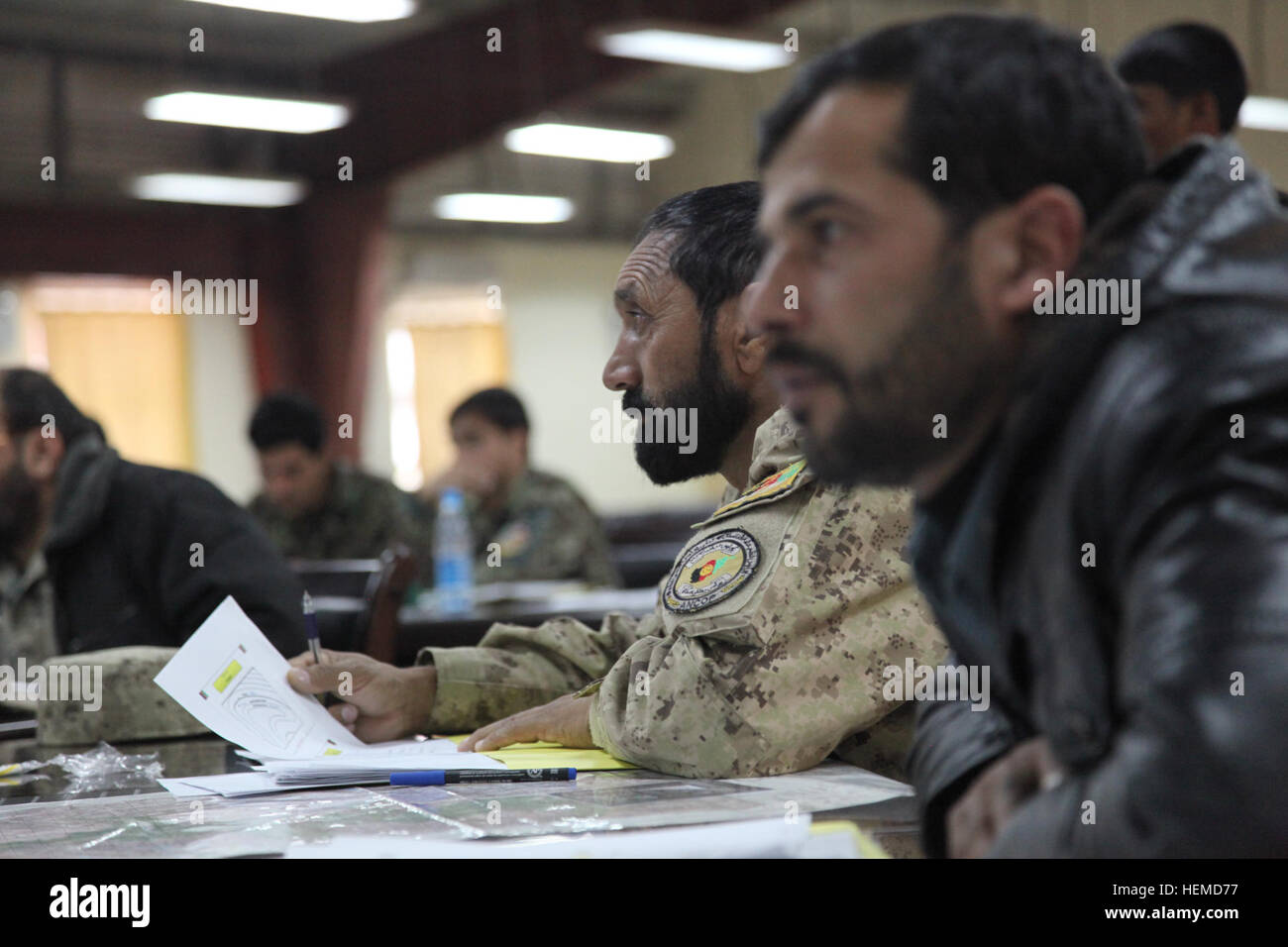 L'ordre civil afghan un policier et un soldat de l'Armée nationale afghane écouter comme quelqu'un s'exprime sur la base d'opération avancée Gamberi, province de Laghman, Afghanistan, 8 janvier 2013. Ils font partie d'une classe d'apprendre à utiliser une boussole et une carte pour tracer des points. (U.S. Photo de l'armée par la CPS. Claire Andrew Baker/libérés) Formation à la BOA Gamberi 130108-A-NI188-090 Banque D'Images