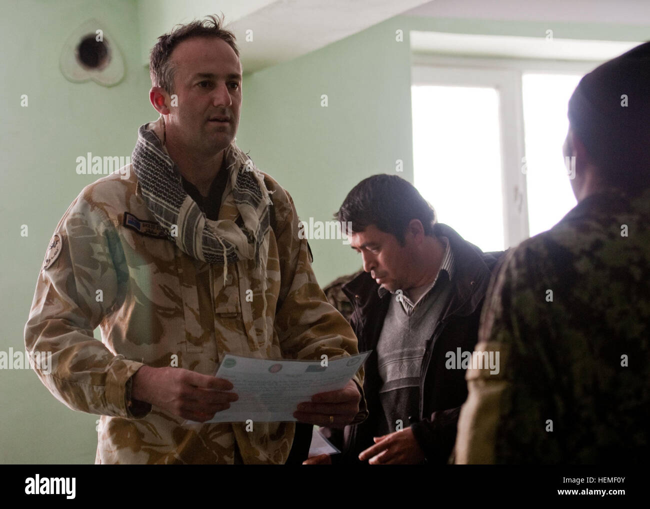 La province de Bamyan, Afghanistan - Le Lieutenant-colonel de l'Armée de Nouvelle-Zélande Sholto Stephens, le commandant de la composante militaire de l'Équipe de reconstruction provinciale de NZ, mains nouvellement diplômée d'un soldat de l'Armée nationale afghane, son diplôme, dans la province de Bamyan, Afghanistan, le 26 février 2013. La NZ PRT a contribué à rassembler la province de Bamyan qu'il est aujourd'hui en développant leurs infrastructures et la formation de leurs forces de sécurité en préparation pour le retrait des forces de la coalition. (U.S. Photo de l'armée par le Sgt. Christopher Bonebrake, Mobile 115e Détachement des affaires publiques), une province de Bamyan dans l Banque D'Images