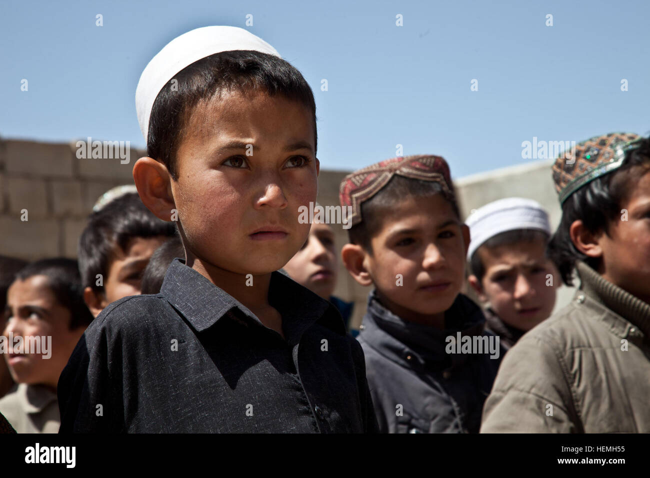 Garçon afghan attend un sac à dos à l'école de garçons en pachto Abad à Ghazni, district de la province de Ghazni, Afghanistan, le 20 avril 2013. Khalilullah Hotak, un membre de l'Nejat Conseil Social de la province de Ghazni, distribué des sacs à dos et d'un bureau à l'école qui enseigne plus de 600 garçons. L'objectif du Conseil Social Nejat est d'éradiquer l'oppression, la corruption, l'injustice et en coordination avec le gouvernement afghan. (U.S. Photo de l'armée par la CPS. Jessica Reyna DeBooy/libérés) en pachto Abad school 130420-A-SL739-168 Banque D'Images