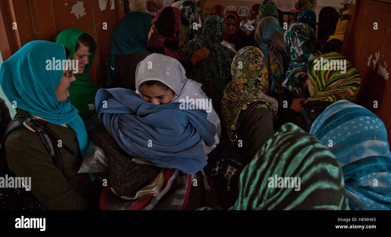 Un enseignants afghans promenades à travers un groupe de femmes avec des fournitures scolaires qu'elle a reçu de Khalilullah Hotak au Jahan Maleeka toutes les filles à l'école dans la province de Ghazni, Afghanistan, district de Ghazni, le 21 avril 2013. L'Jahan Maleeka toutes les filles à l'école, qui enseigne aux plus de 5000 étudiants, ont reçu des fournitures scolaires de l'Nejat membre du Conseil Social Khalilullah Hotak. Le Conseil Social est un Nejat groupe de paix dont le but est d'éradiquer l'oppression, la corruption, l'injustice et en coordination avec le gouvernement afghan. (U.S. Photo de l'armée par la CPS. Jessica Reyna DeBooy/libérés) Jahan Maleeka 130421 école Banque D'Images