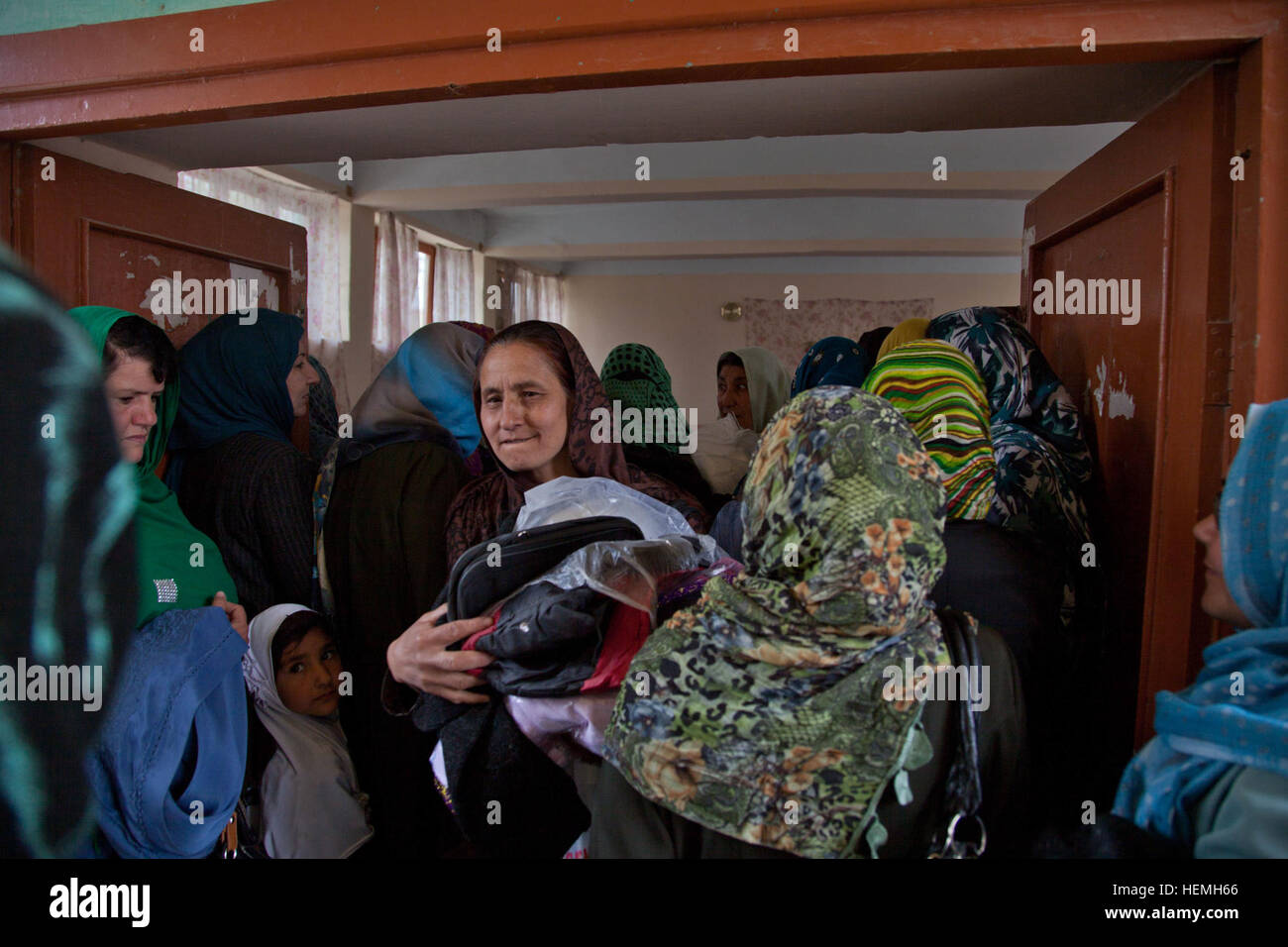 Un enseignants afghans promenades à travers un groupe de femmes avec des fournitures scolaires qu'elle a reçu de Khalilullah Hotak au Jahan Maleeka toutes les filles à l'école dans la province de Ghazni, Afghanistan, district de Ghazni, le 21 avril 2013. L'Jahan Maleeka toutes les filles à l'école, qui enseigne aux plus de 5000 étudiants, ont reçu des fournitures scolaires de l'Nejat membre du Conseil Social Khalilullah Hotak. Le Conseil Social est un Nejat groupe de paix dont le but est d'éradiquer l'oppression, la corruption, l'injustice et en coordination avec le gouvernement afghan. (U.S. Photo de l'armée par la CPS. Jessica Reyna DeBooy/libérés) Jahan Maleeka 130421 école Banque D'Images
