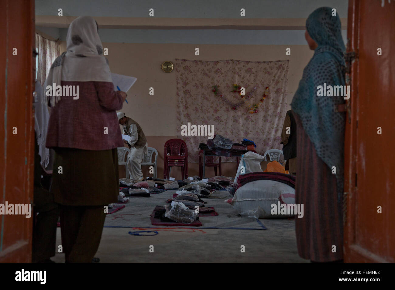 Deux enseignants afghans attendre pour distribuer des fournitures scolaires de Khalilullah Hotak au Jahan Maleeka toutes les filles à l'école dans la province de Ghazni, Afghanistan, district de Ghazni, le 21 avril 2013. L'Jahan Maleeka toutes les filles à l'école, qui enseigne aux plus de 5 000 étudiants, ont reçu des fournitures scolaires de l'Nejat membre du Conseil Social Khalilullah Hotak. Le Conseil Social est un Nejat groupe de paix dont le but est d'éradiquer l'oppression, la corruption, l'injustice et en coordination avec le gouvernement afghan. (U.S. Photo de l'armée par la CPS. Jessica Reyna DeBooy/libérés) Jahan Maleeka school 130421-A-SL739-049 Banque D'Images
