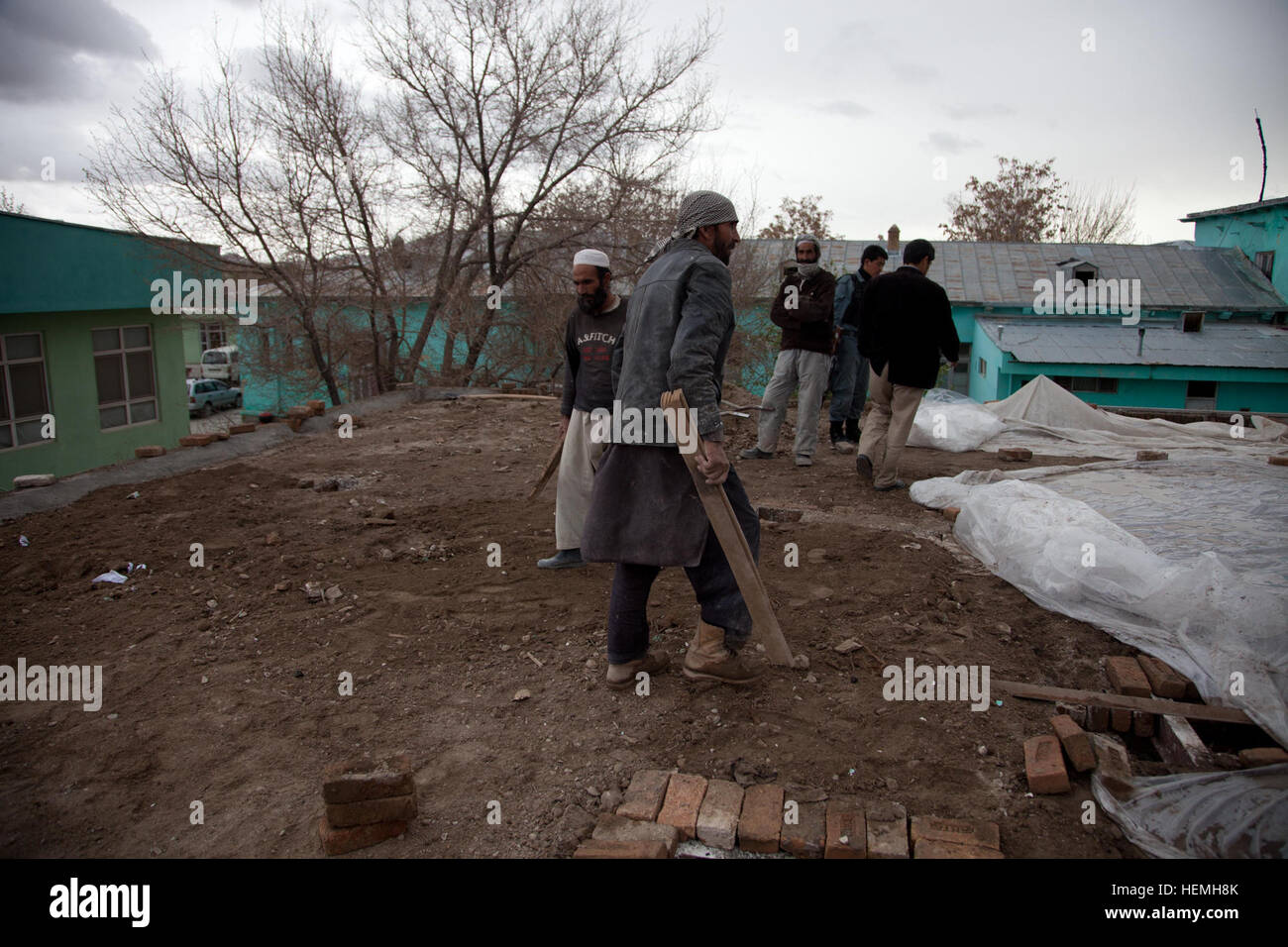 Les travailleurs de la ville afghane fixer en brique sur le toit de l'aile pédiatrique à l'hôpital de la ville de Ghazni Ghazni, district de la province de Ghazni, Afghanistan, le 23 avril 2013. Le 8 mars 2013, un incendie a endommagé le service de pédiatrie. Les fonds pour rénover le service de pédiatrie ont été demandés par le directeur du ministère de la santé, à travers le Asfandi Gul Zya Nejat Conseil Social de la ville de Ghazni. Le Conseil Social est un Nejat groupe de paix dont le but est d'éradiquer l'oppression, la corruption, l'injustice et en coordination avec le gouvernement afghan. (U.S. Photo de l'armée par la CPS. Jessica Reyna DeBooy) Parution/École Naswan Shaher Kohna Banque D'Images