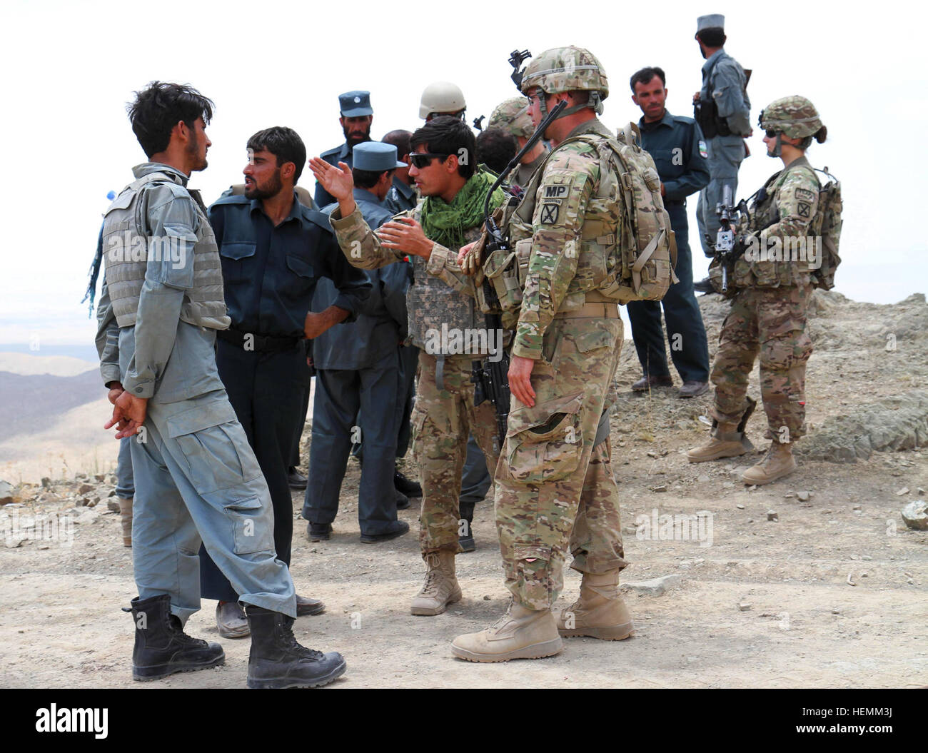 Le capitaine de l'armée américaine Daniel Maxfield le directeur général affecté à Blue 0 de l'Équipe consultative des forces de sécurité afghanes et interprète à la fois en poste à l'avant de la base de l'opération Rushmore, la province de Paktika discuter Omna opération avec un membre de la police uniforme afghane stationnée dans le district Omna, le 6 juillet 2013. Les FSNA exécuté leur mission rapidement avec peu de considération, laissant les forces de la coalition ont peu à faire, mais suivre le long de fournir un soutien essentiel en cas de besoin. (Photo prise par le sergent de l'armée américaine. Mark A. Moore II - 2/10 l'aide les forces de sécurité) Brigade FSNA Omna sécurisé 130706-A-XX999-001 Banque D'Images