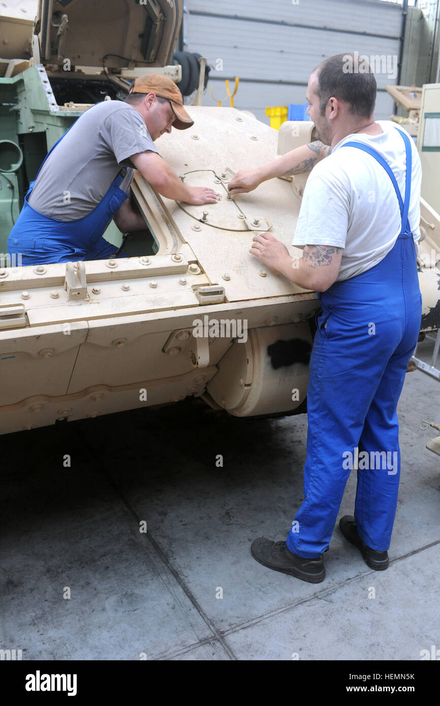 Üwe Richter, droite, et Patrick Müller, à gauche, les deux mécaniciens de machinerie lourde avec l'activité de maintenance Kaiserslautern et autochtones de Kaiserlsautern et Altenkirchen, l'Allemagne, respectivement, mettre des morceaux de un M2A2 véhicule de combat Bradley retour ensemble à Kaiserslautern, dépôt de l'armée le 30 juillet. Le 21e Commandement de soutien du théâtre Théâtre de l'appui logistique et Center-Europe retrograding MAK sont responsables d'un total de 88 Bradleys Both. Fin d'une époque, Final Des BCT Bradleys both depart Allemagne 130730-A-UV471-440 Banque D'Images