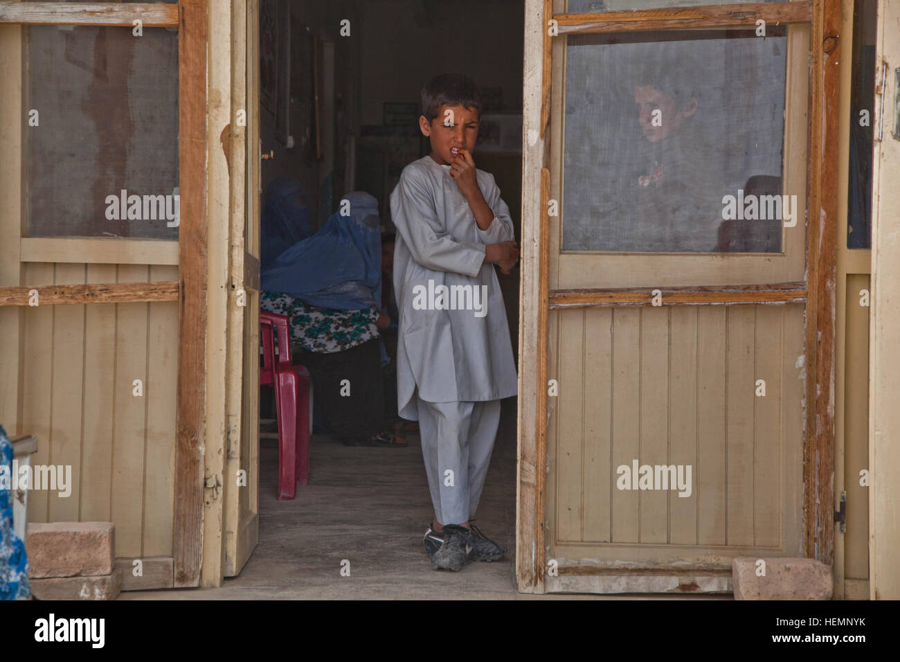 Un garçon afghan attend un séminaire médical à démarrer à une clinique communautaire à Deh Yak, district de la province de Ghazni, Afghanistan, le 19 août 2013. Cinquante hommes et femmes de district de Deh Yak et des environs ont assisté aux trois jours de séminaire médical, qui couvre des sujets tels que les premiers soins d'urgence, de l'assainissement, les techniques d'accouchement, et la nutrition. (U.S. Photo de l'armée par la CPS. Jessica Reyna DeBooy/libérés) Enduring Freedom 130818-A-SL739-017 Banque D'Images