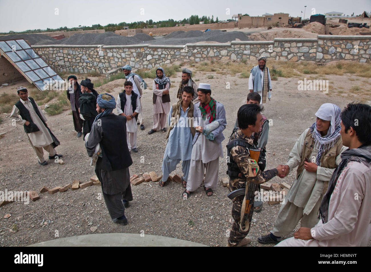 Les hommes afghans se tiennent à l'extérieur attendent leur femme après un séminaire médical à une clinique communautaire à Deh Yak, district de la province de Ghazni, Afghanistan, le 19 août 2013. Cinquante hommes et femmes de district de Deh Yak et des environs ont assisté aux trois jours de séminaire médical, qui couvre des sujets tels que les premiers soins d'urgence, de l'assainissement, les techniques d'accouchement, et la nutrition. (U.S. Photo de l'armée par la CPS. Jessica Reyna DeBooy/libérés) Enduring Freedom 130818-A-SL739-025 Banque D'Images