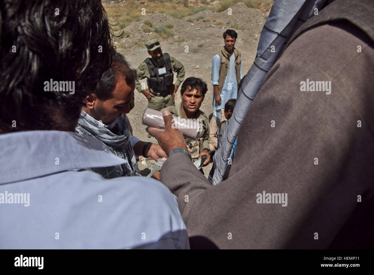 Les sections locales et la police locale afghane se rassemblent autour de recevoir des fournitures médicales au cours d'un séminaire médical à Deh Yak, district de la province de Ghazni, Afghanistan, le 19 août 2013. Cinquante hommes et femmes de district de Deh Yak et des environs ont assisté aux deux jours de séminaire médical, qui couvre des sujets tels que les premiers soins d'urgence, de l'assainissement, les techniques d'accouchement, et la nutrition. (U.S. Photo de l'armée par la CPS. Jessica Reyna DeBooy/libérés) Enduring Freedom 130819-A-SL739-046 Banque D'Images