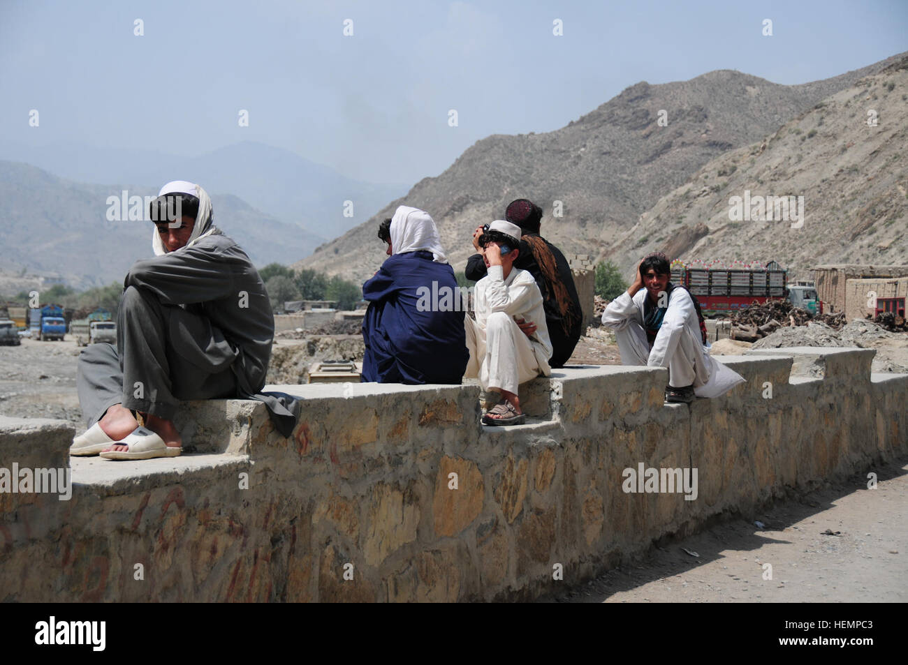 Un groupe de jeunes Afghans s'asseoir sur un pont à regarder comme des soldats de la 617e compagnie du génie, 864e bataillon du génie, 555e Brigade du génie et une compagnie, 4e Bataillon des troupes spéciales de la Brigade, 4e Brigade Combat Team, 101st Airborne Division (Air Assault), faire des réparations à une section de l'Khowst-Gardez Route qui a été lavée à cause des fortes pluies plusieurs semaines plus tôt dans la province de Khowst, Afghanistan, le 28 août. (U.S. Photo de l'armée par le Sgt. Joshua B. Dwyer, 4e Brigade Combat Team) Affaires publiques réparation Ingénieurs road 130828-A-RN538-020 Banque D'Images