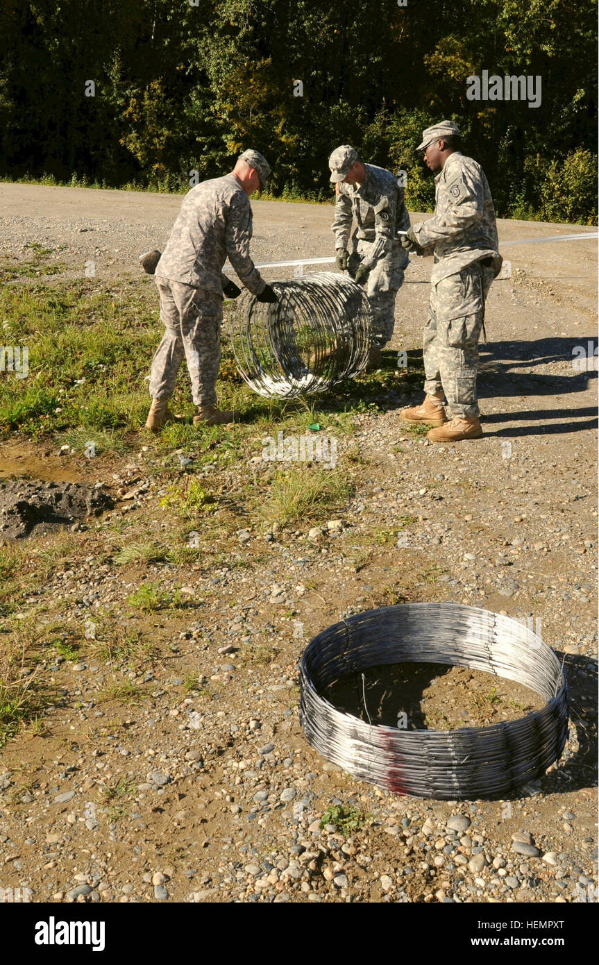 Des soldats de la Compagnie de la Police militaire de la 472nd, 793e Bataillon de la Police militaire mis en place des fils concertina pour renforcer la sécurité du périmètre près du point de contrôle d'entrée d'une maquette site sécurisé dans le cadre d'un exercice de certification tenu le Fort Wainwright, en préparation pour un prochain déploiement. (U.S. Photo de l'armée par le sergent. Trish McMurphy, USARAK) Affaires publiques Fort Wainwright  % % % % % % % %E2 % % % % % % % %80 % % % % % % % %99s 472nd entreprise procède à la Police militaire de l'exercice de certification 130911-A-RT214-199 Banque D'Images