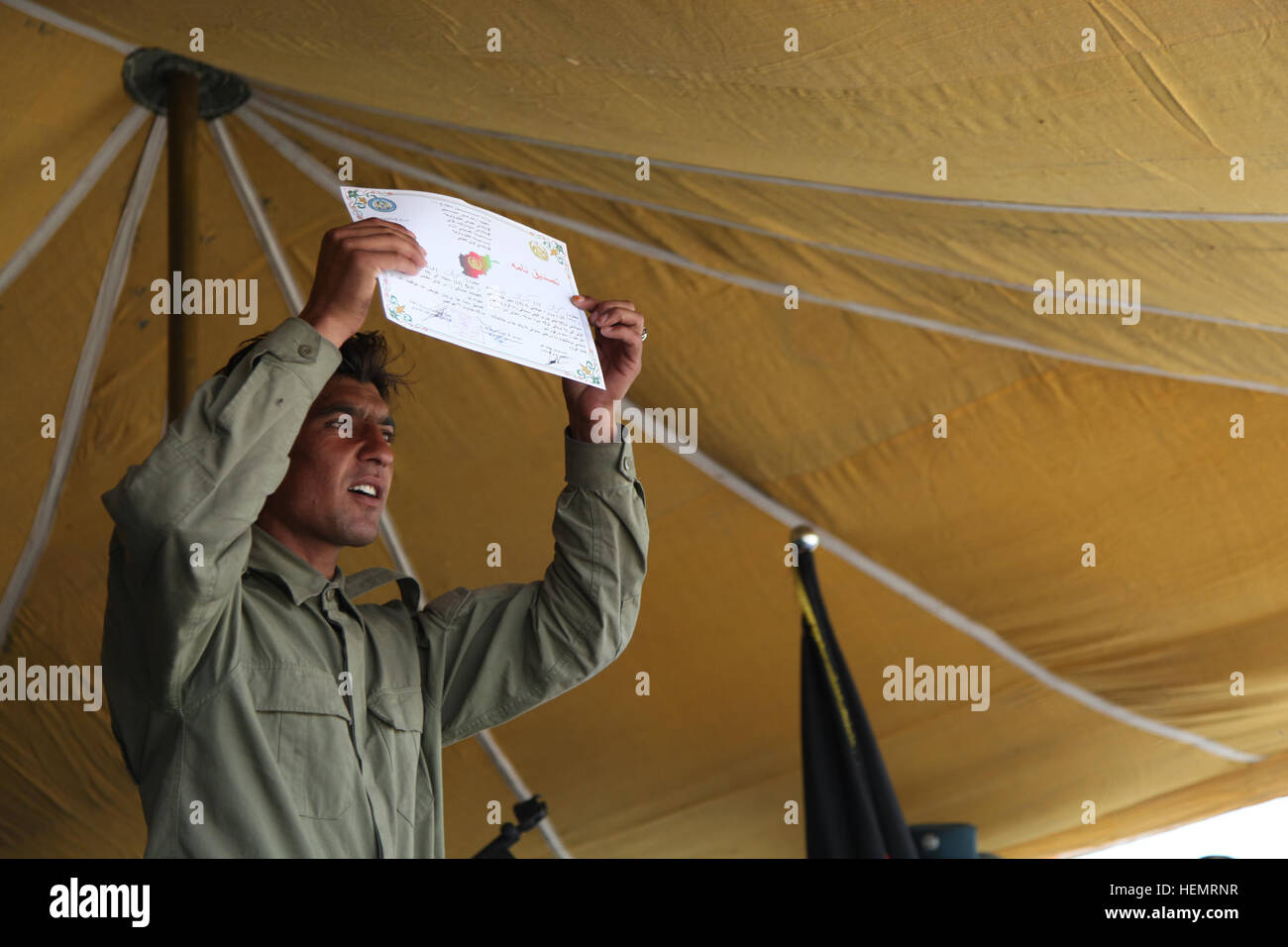 La police locale afghane (ALP) stagiaire détient son certificat d'achèvement pendant le jour de graduation, Ghazni, district de la province de Ghazni, Afghanistan, le 26 septembre 2013. L'ALP 57 stagiaires ont assisté à des diplômes au centre de formation de la province de Ghazni après une longue semaine trois plomb afghan ALP programme qui porte sur le développement professionnel, les techniques médicales, petite unité tactique, et de compétences d'armes. (U.S. Photo de l'armée par la CPS. Jessica Reyna DeBooy/libérés) Se préparer pour l'obtention du diplôme 130926-A-SL739-069 Banque D'Images