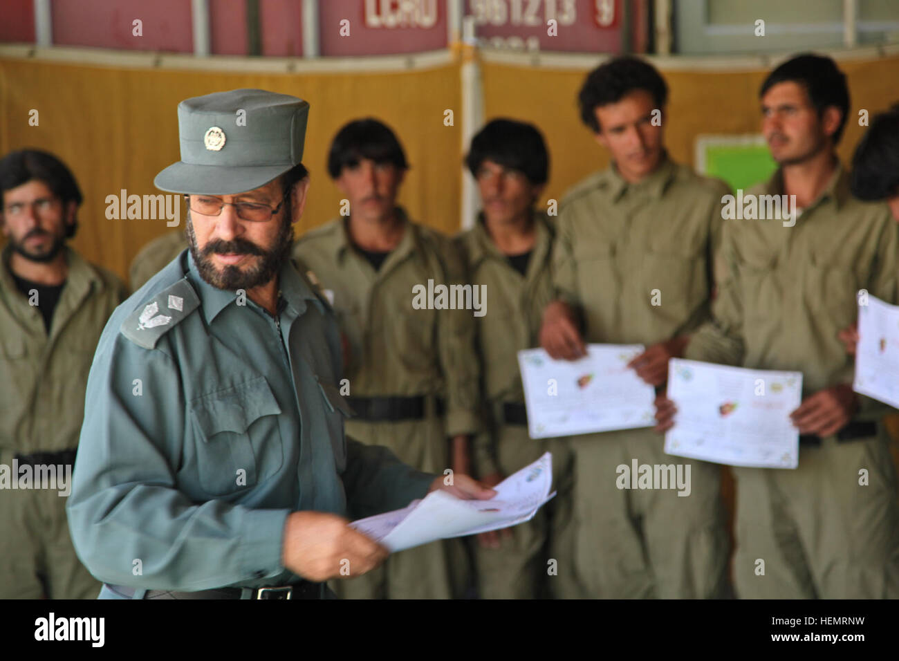 Akbar le grand centre de formation de la province, le commandant remet les certificats d'achèvement de la police locale afghane (ALP) stagiaires au cours de graduation day, Ghazni, district de la province de Ghazni, Afghanistan, le 26 septembre 2013. L'ALP 57 stagiaires préparé pour le jour de la remise des diplômes au centre de formation de la province de Ghazni après une longue semaine trois plomb afghan ALP programme qui porte sur le développement professionnel, les techniques médicales, petite unité tactique, et de compétences d'armes. (U.S. Photo de l'armée par la CPS. Jessica Reyna DeBooy/libérés) Se préparer pour l'obtention du diplôme 130926-A-SL739-075 Banque D'Images