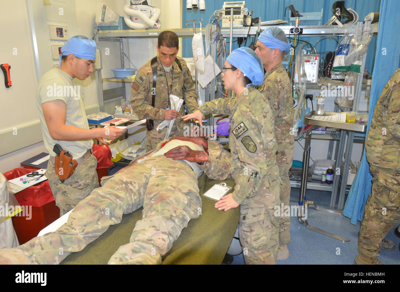 A l'aérodrome de Kandahar, hôpital de rôle 3 déterminer la meilleure façon d'aider un patient avec une 'fausse blessure à la main, à la poitrine et au visage au cours d'un exercice d'un grand nombre de blessés, le 14 février 2014. L'exercice comportait de répondre à du personnel blessé à partir de l'écrasement d'un hélicoptère civil et le tri et le mouvement des blessés à des niveaux de soins. (U.S. Photo de l'armée par le Capitaine Andrew Cochran/libérés) Aide est ici 140214-A-VT601-349 Banque D'Images