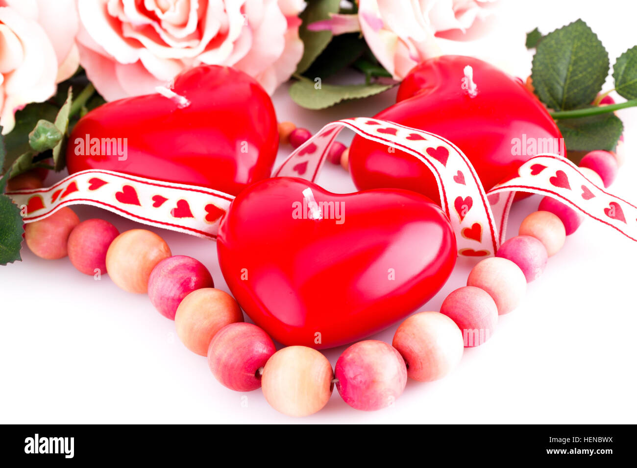 Coeur rouge collier en bois, bougies et ruban sur fond blanc. Banque D'Images