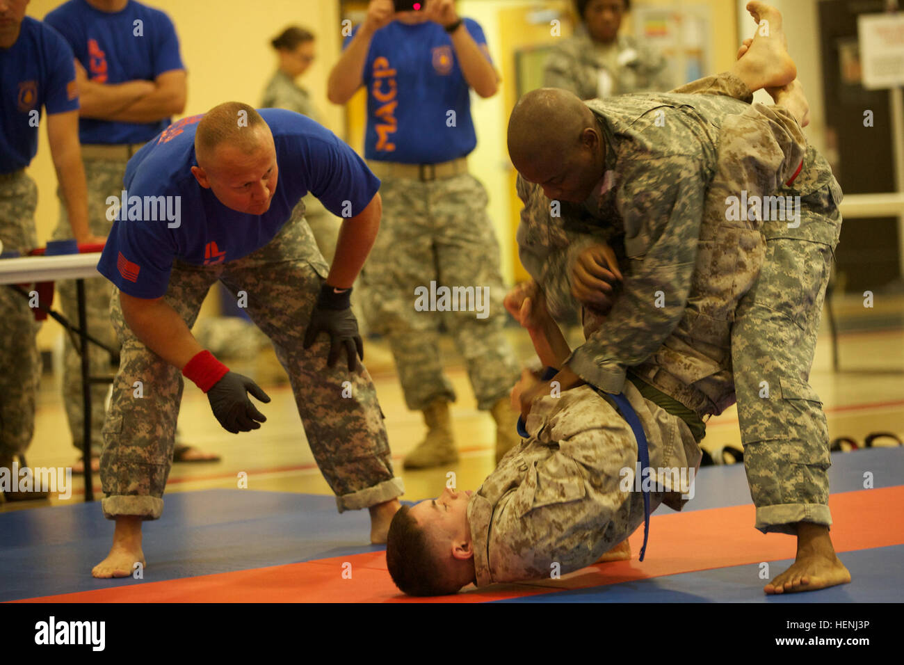 Un soldat de l'armée américaine et de la Marine américaine lutte tête à tête de l'armée au cours d'un tournoi Combatives à Fort Dix, N.J., le 7 juin 2014. Ce tournoi comprend des soldats, aviateurs et marins en compétition dans différentes catégories de poids pour une chance de gagner le titre. (U.S. Photo de l'armée par le Sgt. Austin Berner/libérés) 98e tournoi de la Division Army Combatives 140607-A-BZ540-195 Banque D'Images
