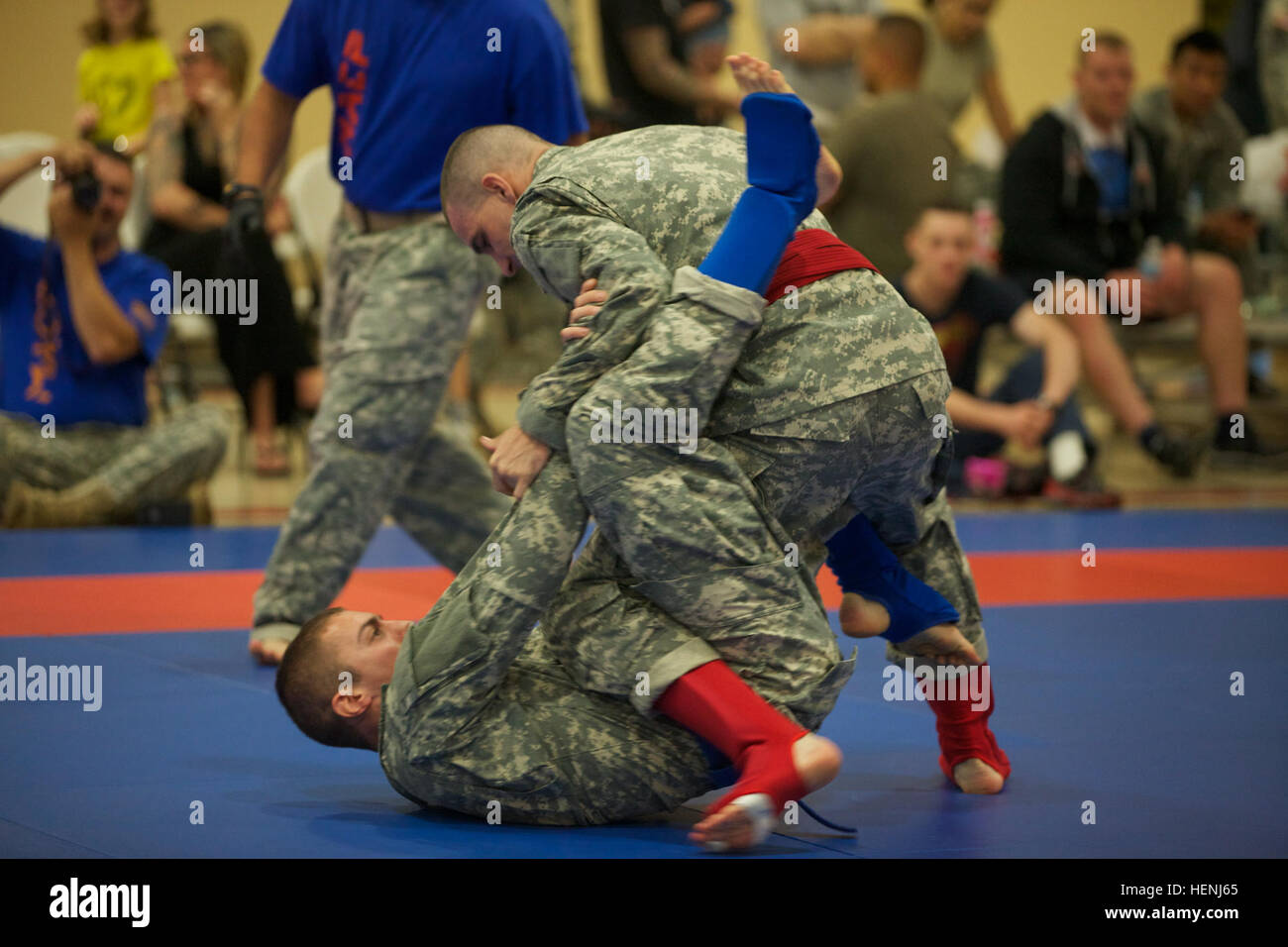 Deux soldats de l'armée américaine se battre entre eux, tout en étant observés par un arbitre pendant un tournoi combatives de l'armée à Fort Dix, N.J., le 8 juin 2014. Ce tournoi comprend des soldats, aviateurs et marins, en compétition dans différentes catégories de poids pour une chance de gagner le titre. (U.S. Photo de l'armée par le Sgt. Austin Berner/libérés) 98e tournoi de la Division Army Combatives 140608-A-BZ540-031 Banque D'Images