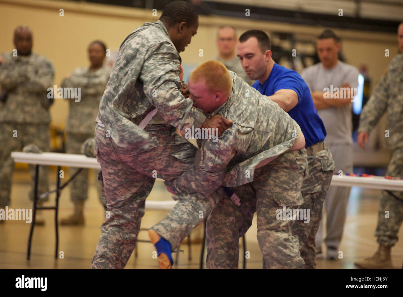 Deux soldats de l'armée américaine se battre entre eux, tout en étant observés par un arbitre pendant un tournoi combatives de l'armée à Fort Dix, N.J., le 8 juin 2014. Ce tournoi comprend des soldats, aviateurs et marins, en compétition dans différentes catégories de poids pour une chance de gagner le titre. (U.S. Photo de l'armée par le Sgt. Austin Berner/libérés) 98e tournoi de la Division Army Combatives 140608-A-BZ540-059 Banque D'Images
