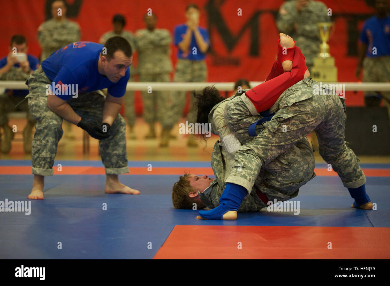 Deux soldats de l'armée américaine se battre entre eux, tout en étant observés par un arbitre pendant un tournoi combatives de l'armée à Fort Dix, N.J., le 8 juin 2014. Ce tournoi comprend des soldats, aviateurs et marins, en compétition dans différentes catégories de poids pour une chance de gagner le titre. (U.S. Photo de l'armée par le Sgt. Austin Berner/libérés) 98e tournoi de la Division Army Combatives 140608-A-BZ540-075 Banque D'Images